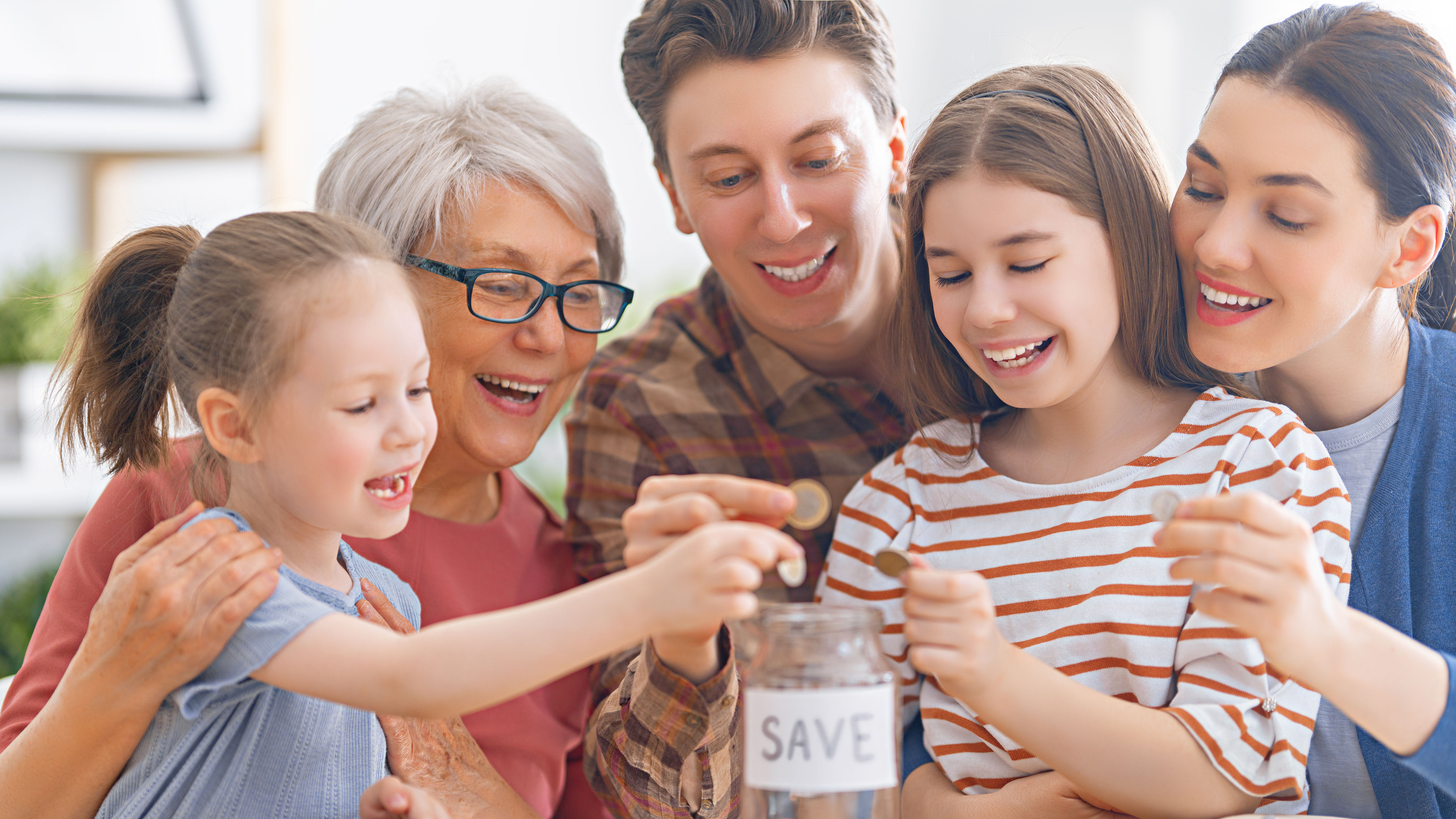 A family putting money into a glass jar 