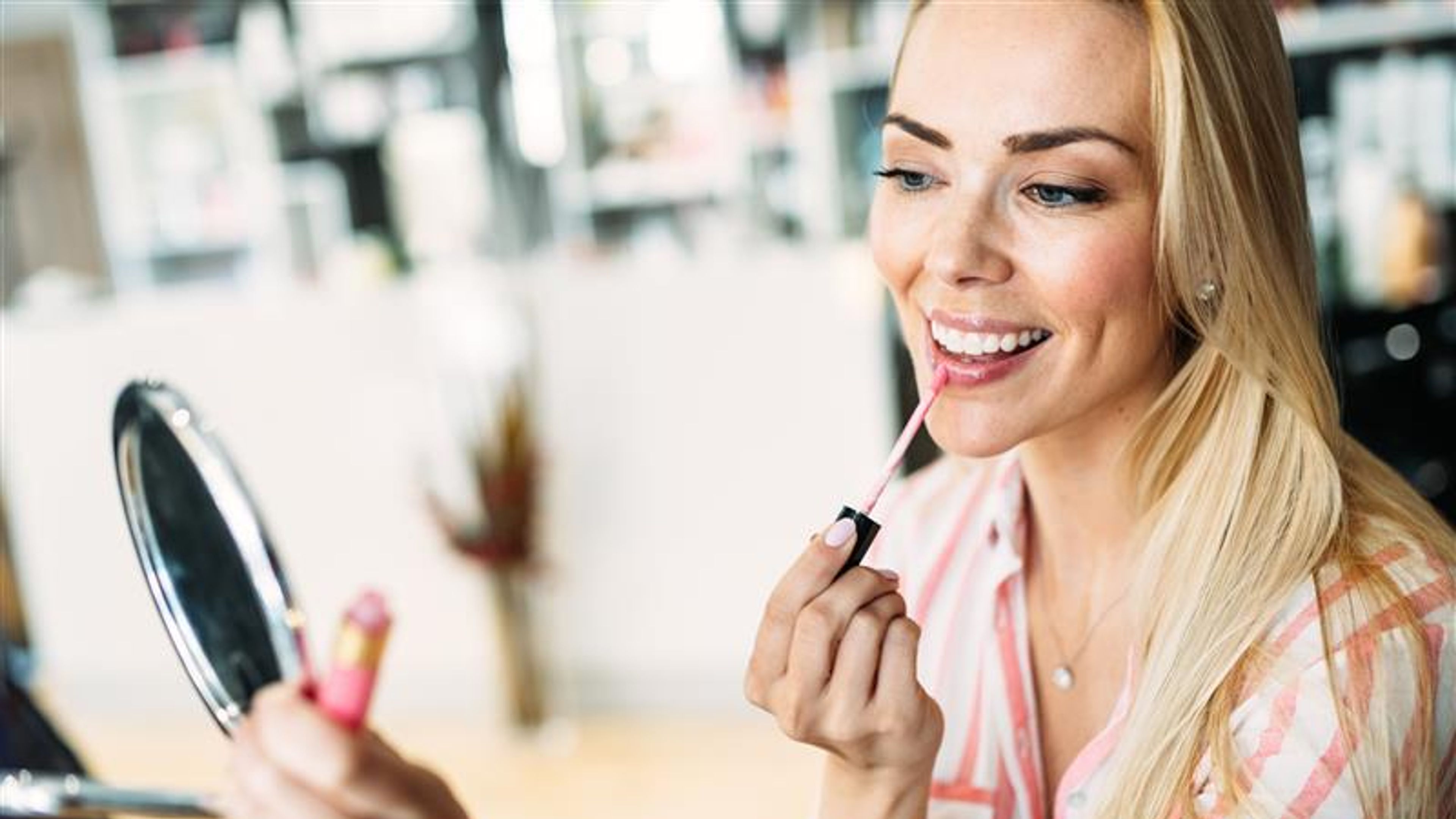 A young woman trying lipstick