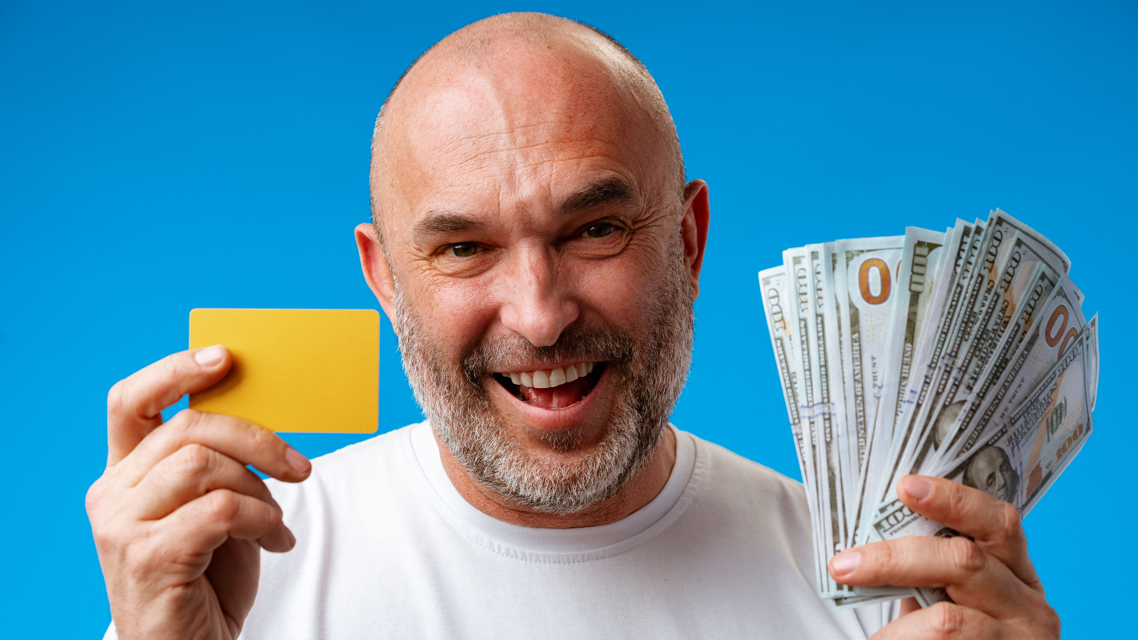 surprised man holding dollar bills and credit card 