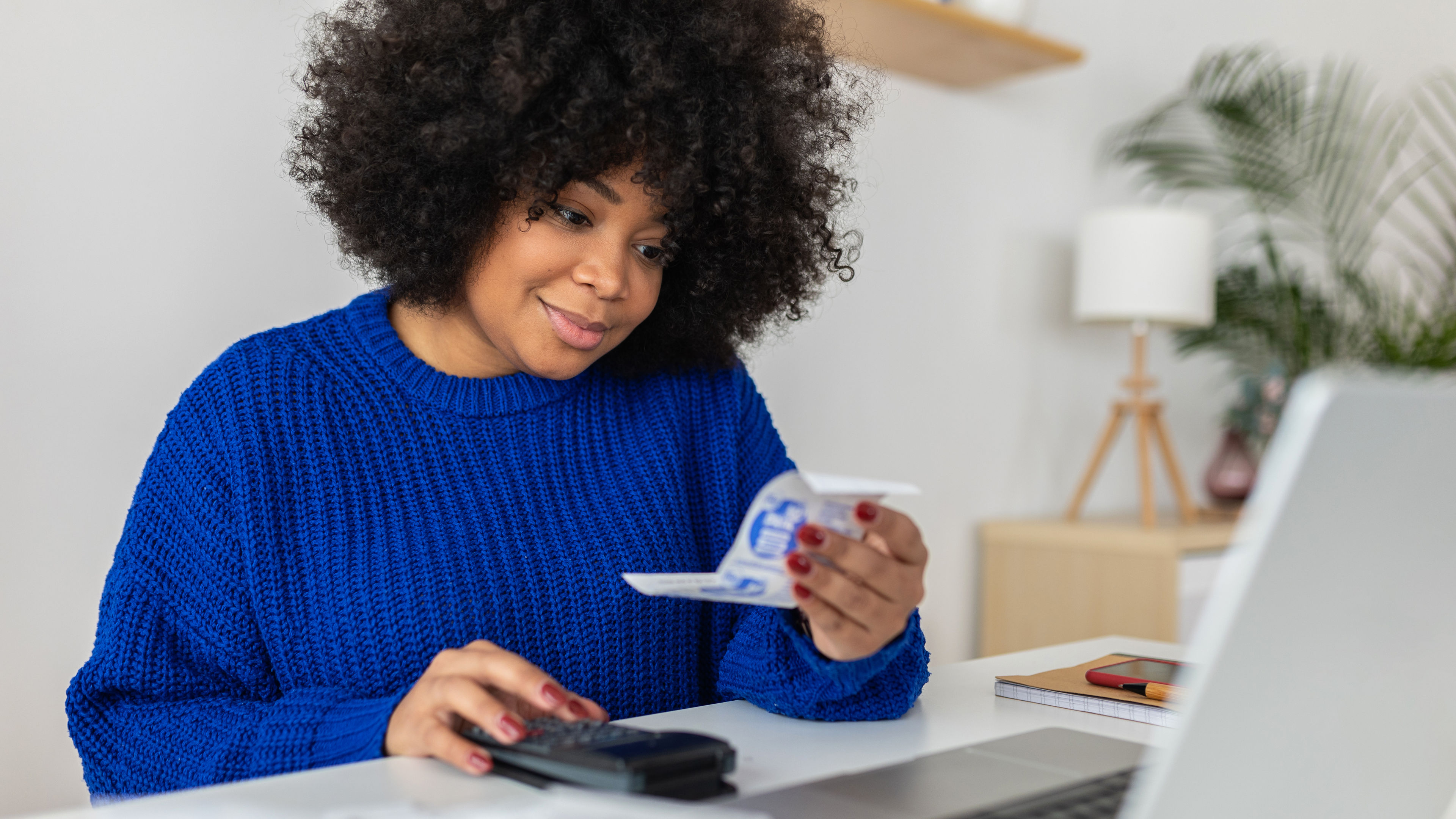 Young latin american woman managing budget and expenses bills at home. 