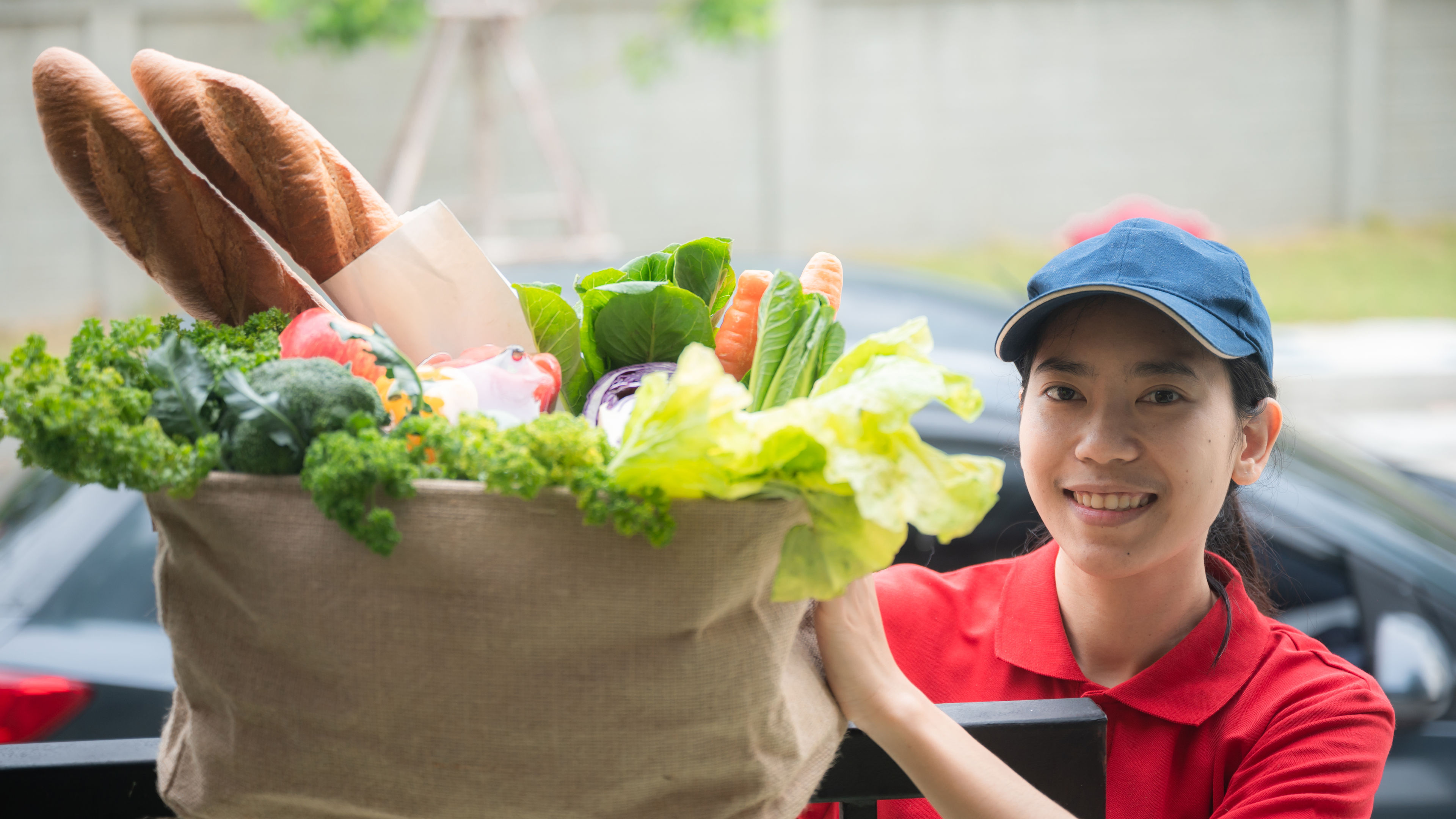 Isang delivery woman na may hawak na ilang groceries