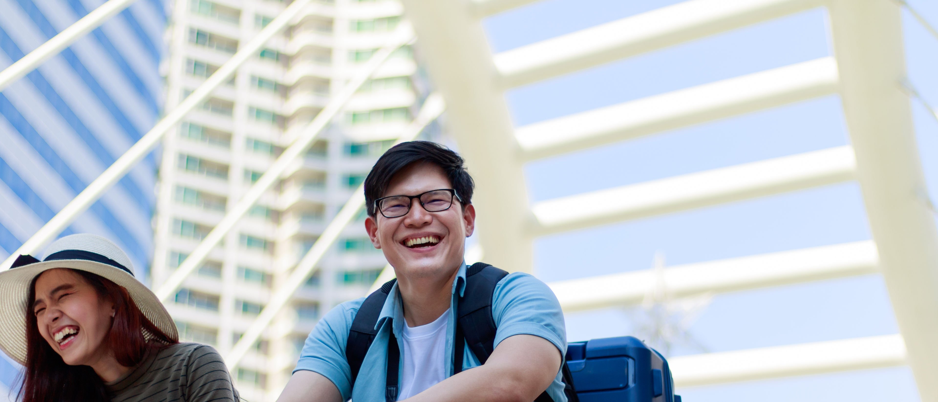 Isang babae at isang lalaki na nakaupo na may hawak na mga bag ng turista