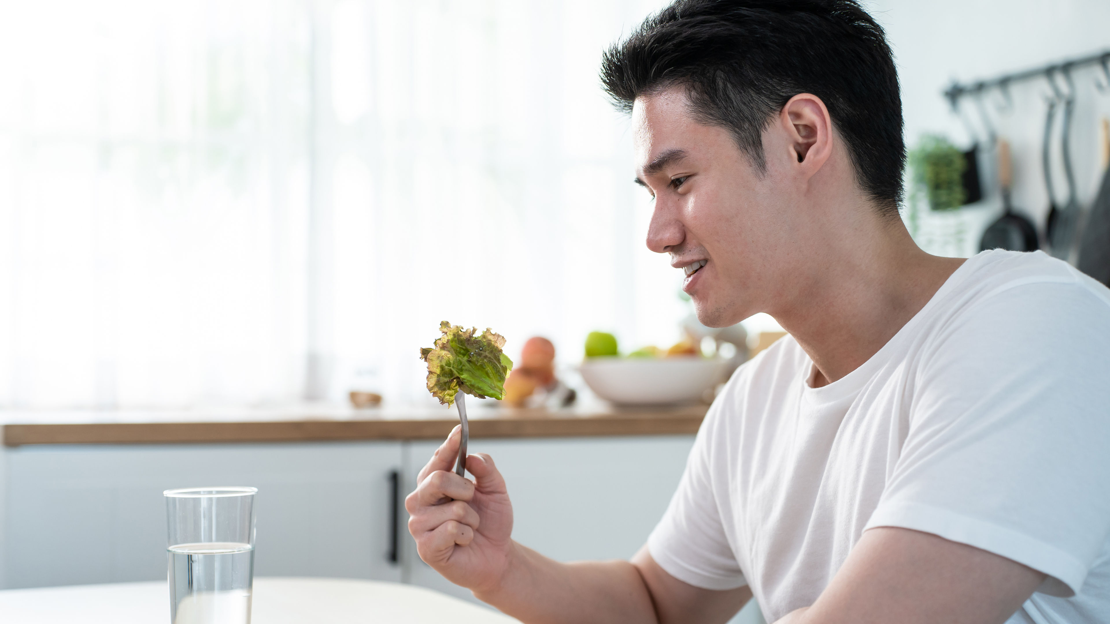 Lalaki kumakain ng salad sa bahay 