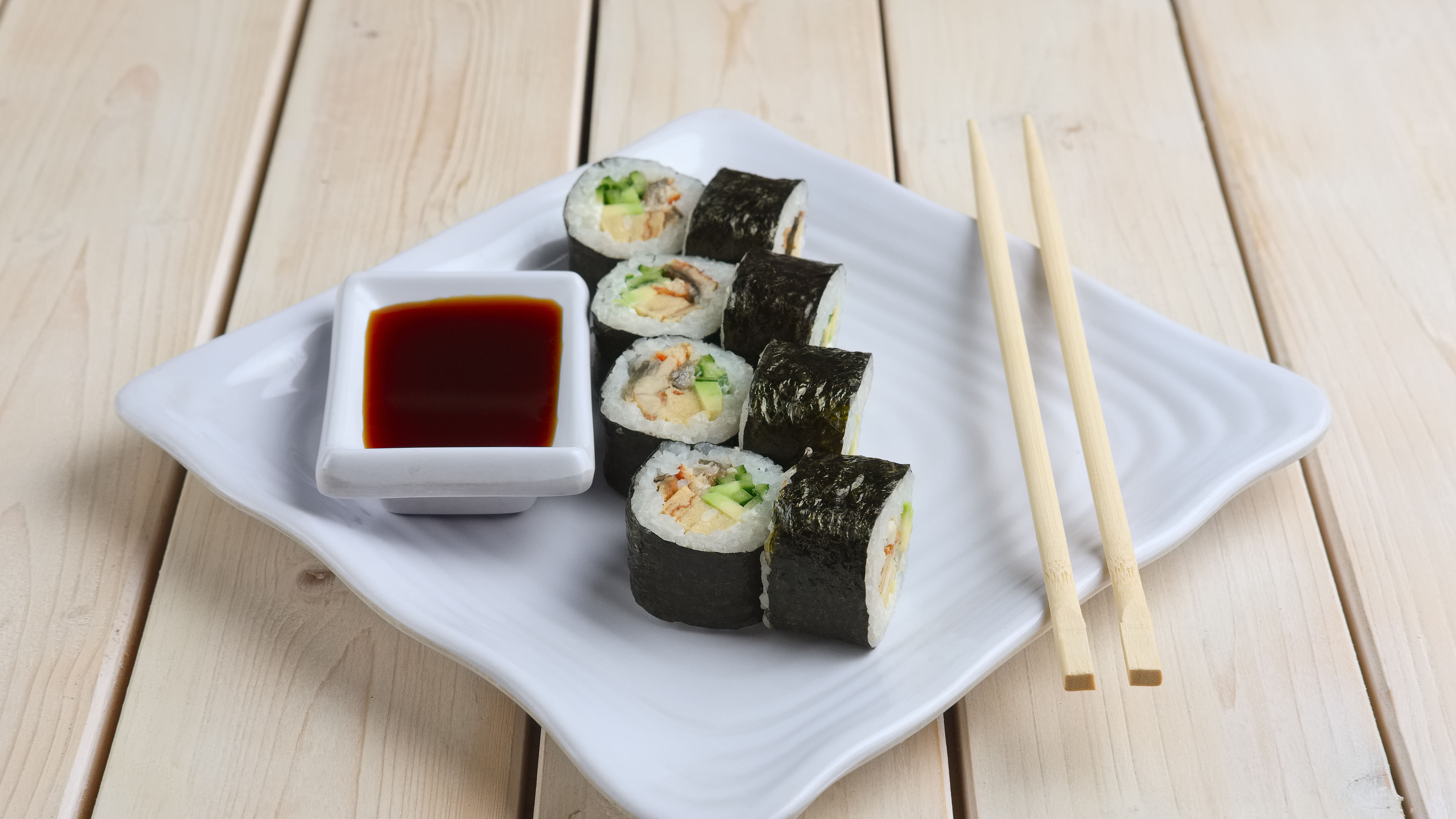 Set ng mga roll na may salmon, abukado at pipino sa plato na may toyo 