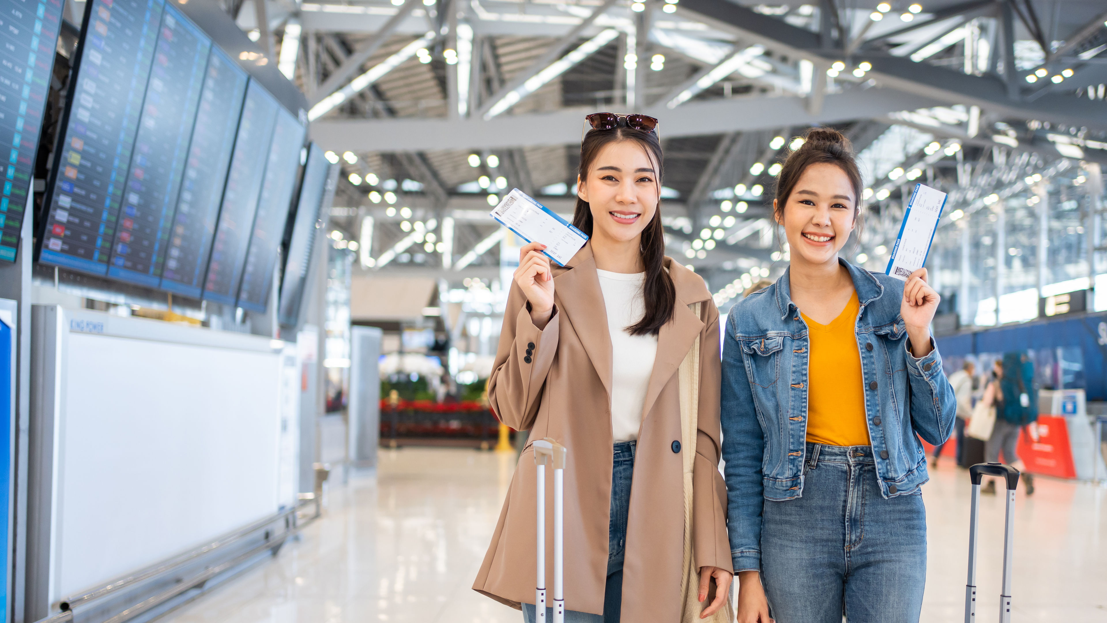 Portrait of Asian women standing in airport terminal at boarding gate.