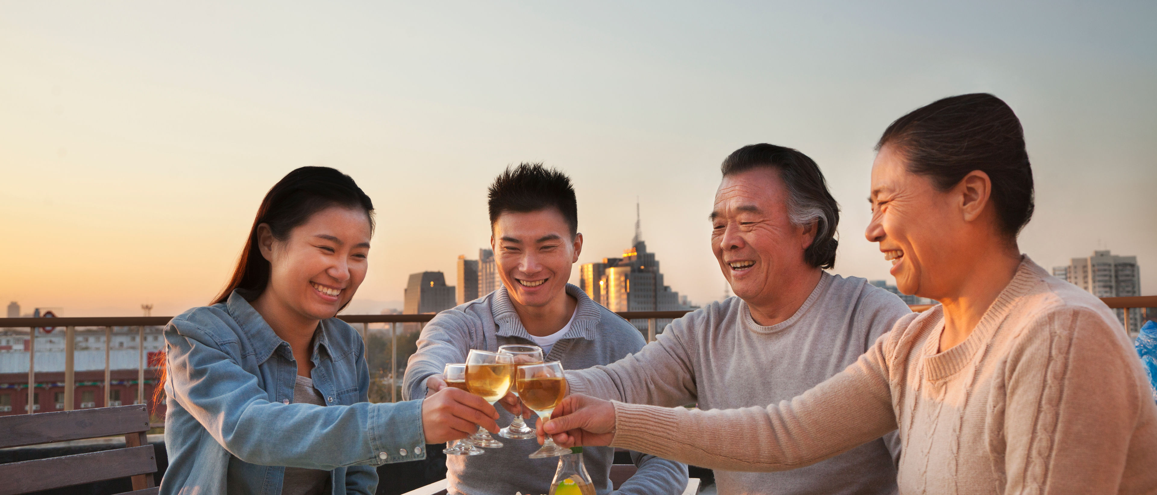 A family of four enjoying food and drinks