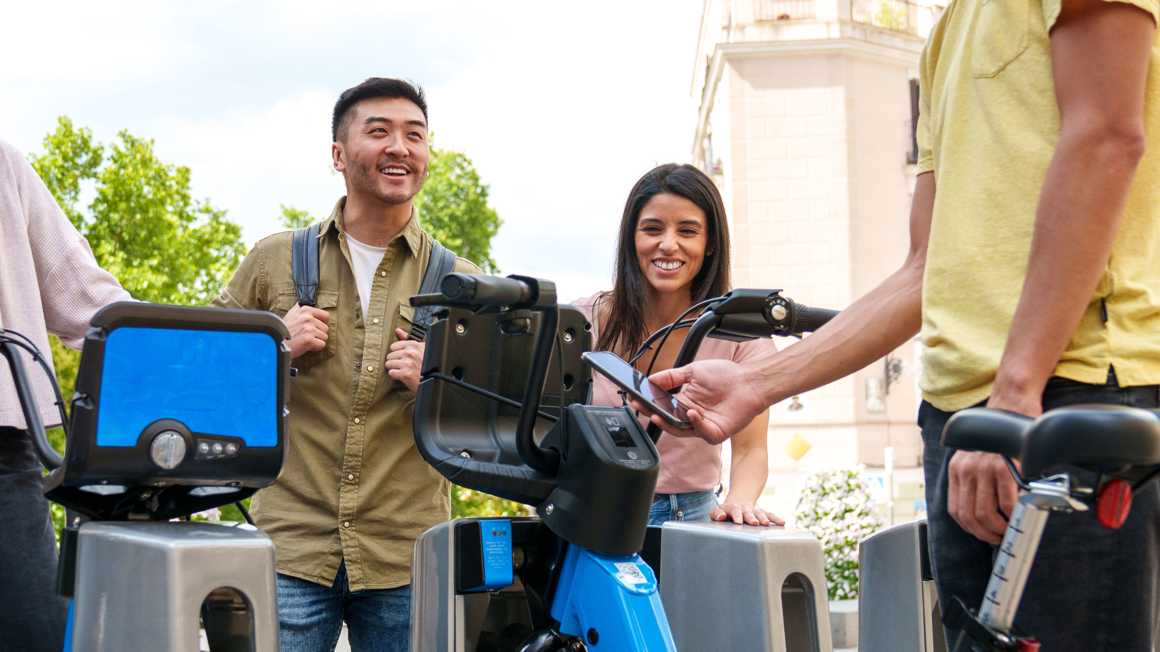 Joyful Multiethnic Youths Renting Electric Bikes on Sunny Day Asian Boy Arriving with Caucasian Girl 