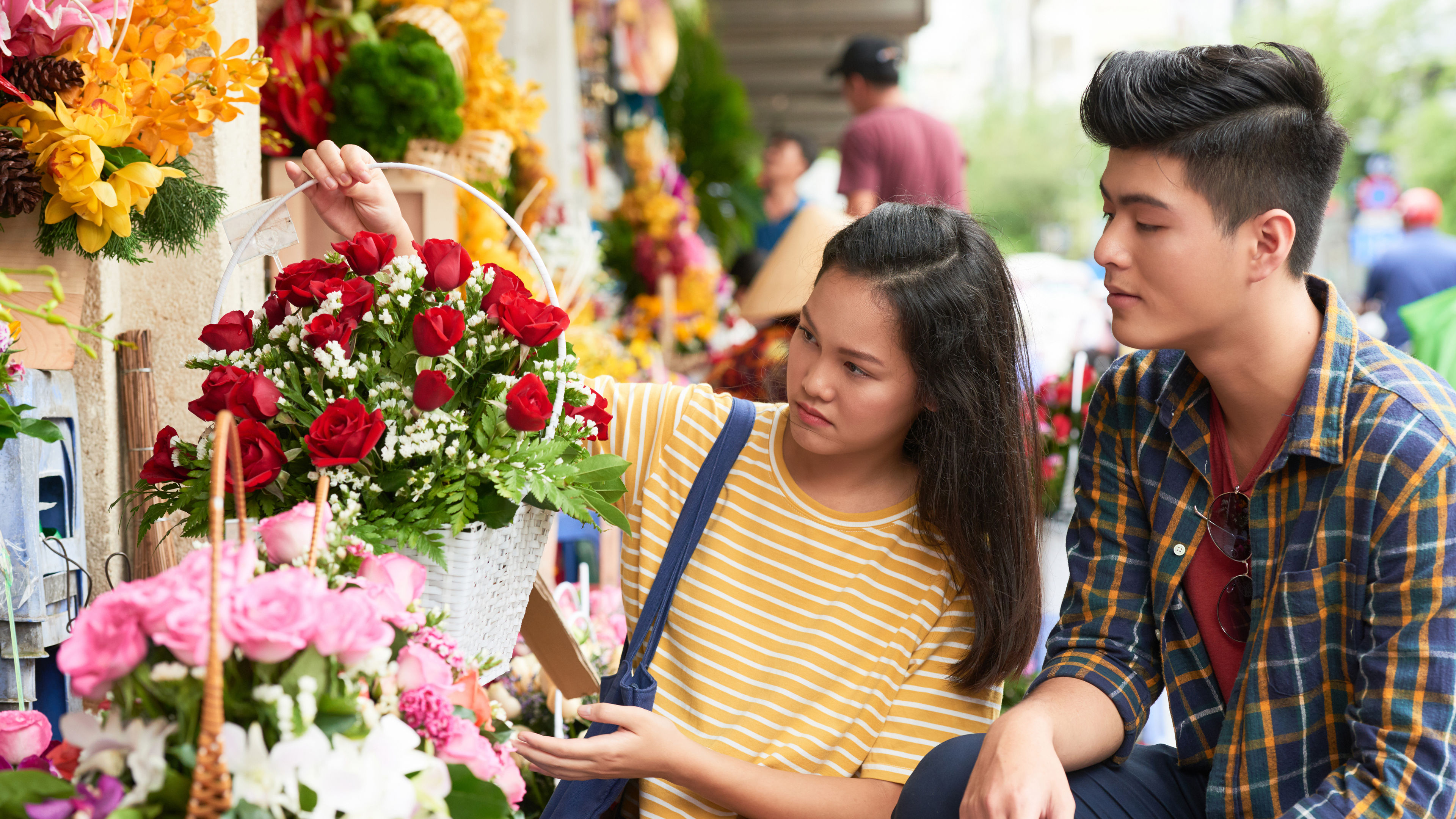 A young Asian couple shopping red and pink roses.