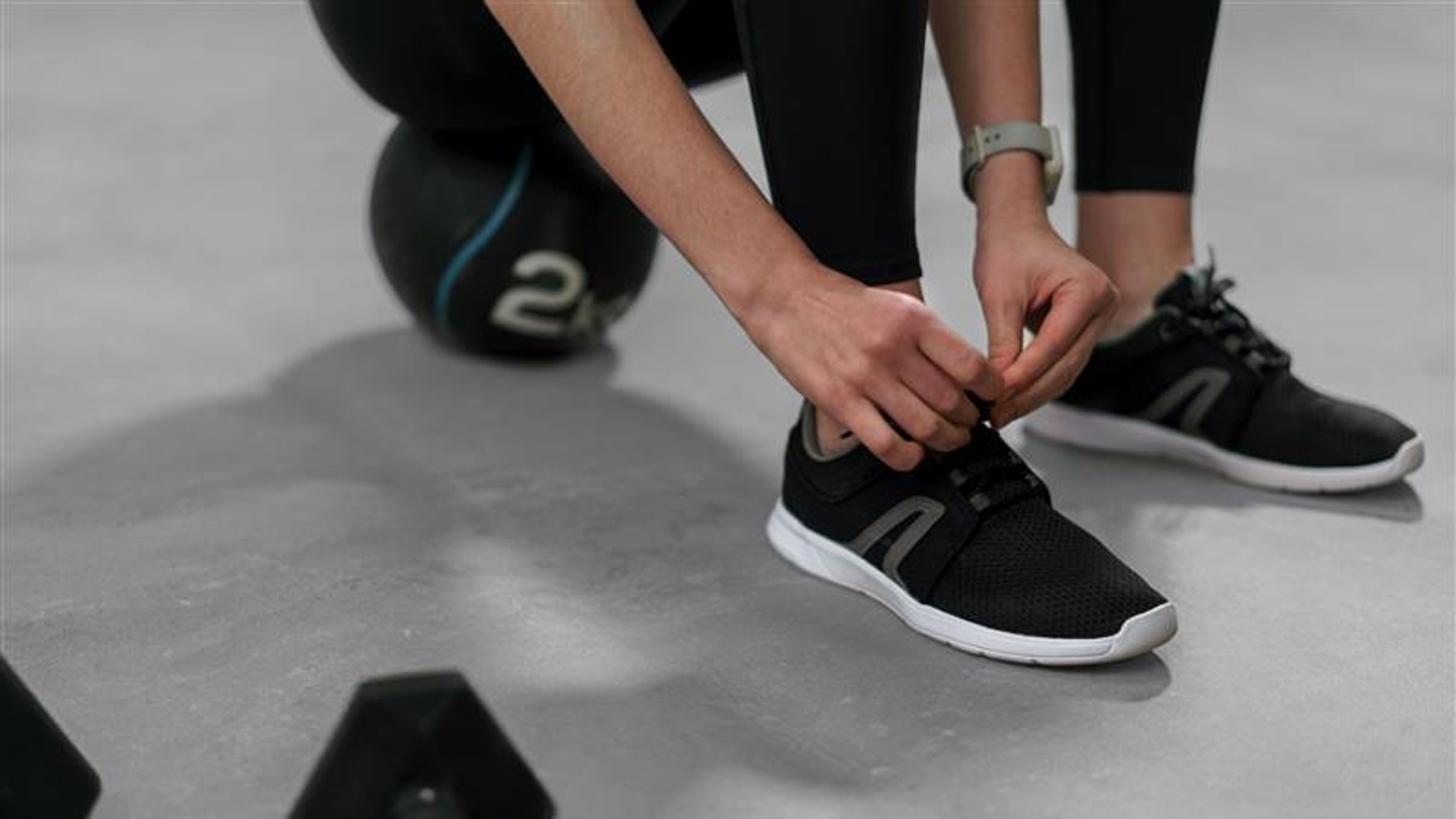 A close-up of woman Hands Tying Shoelaces On Fashion Sneakers 