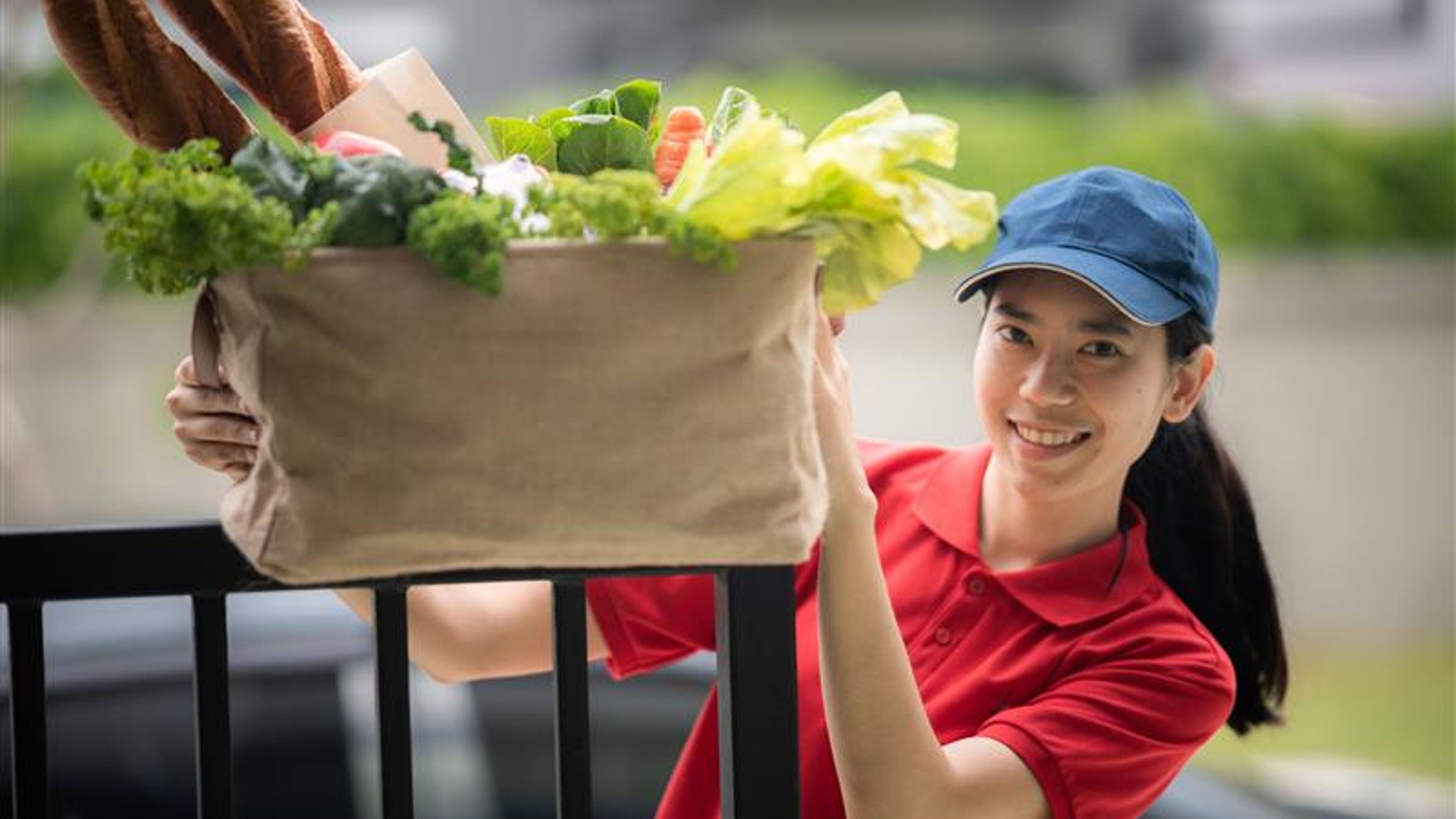 A young woman with a parcel with vegetables in hand 