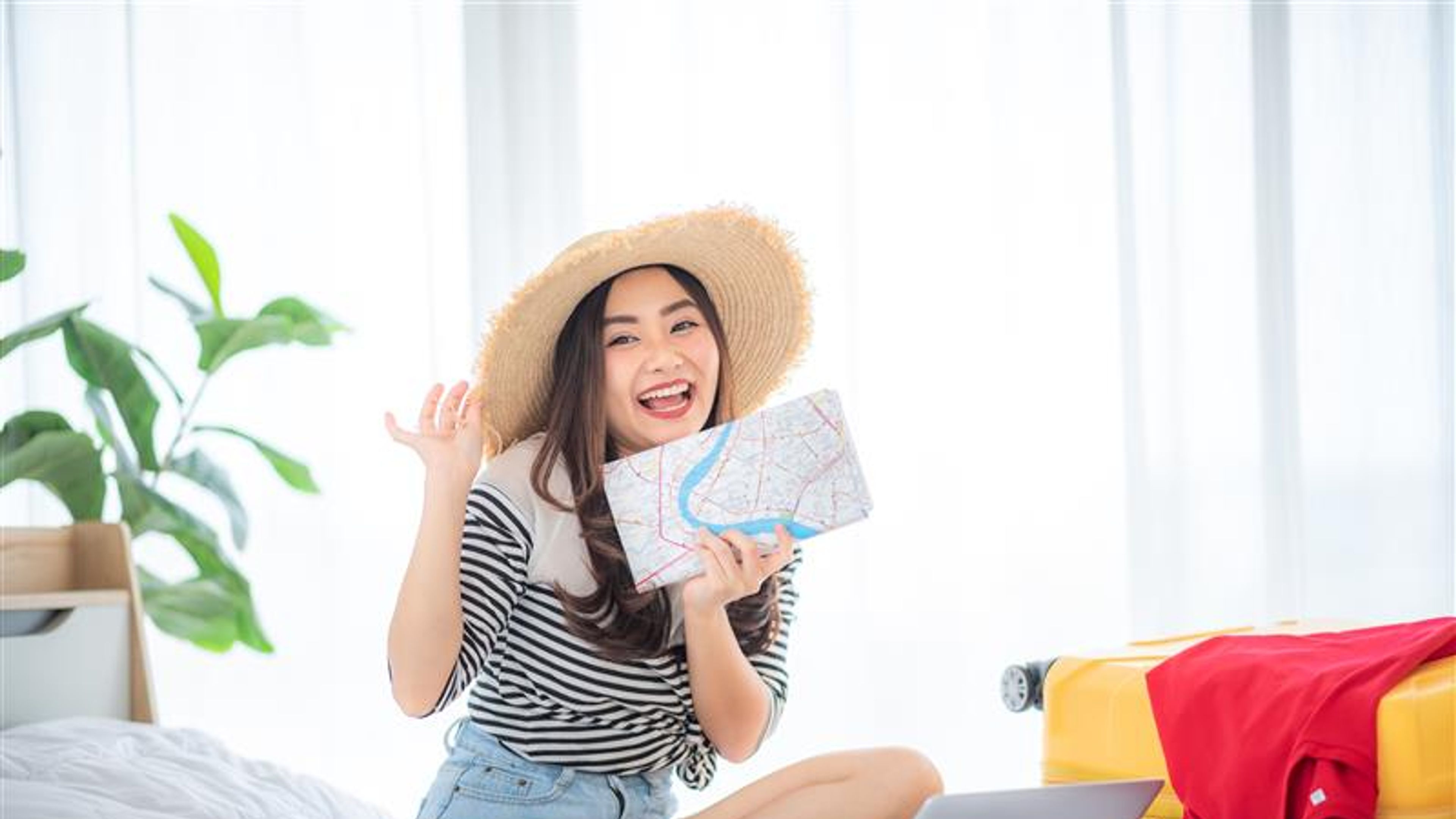 A young Asian woman travel with a yellow suitcase 