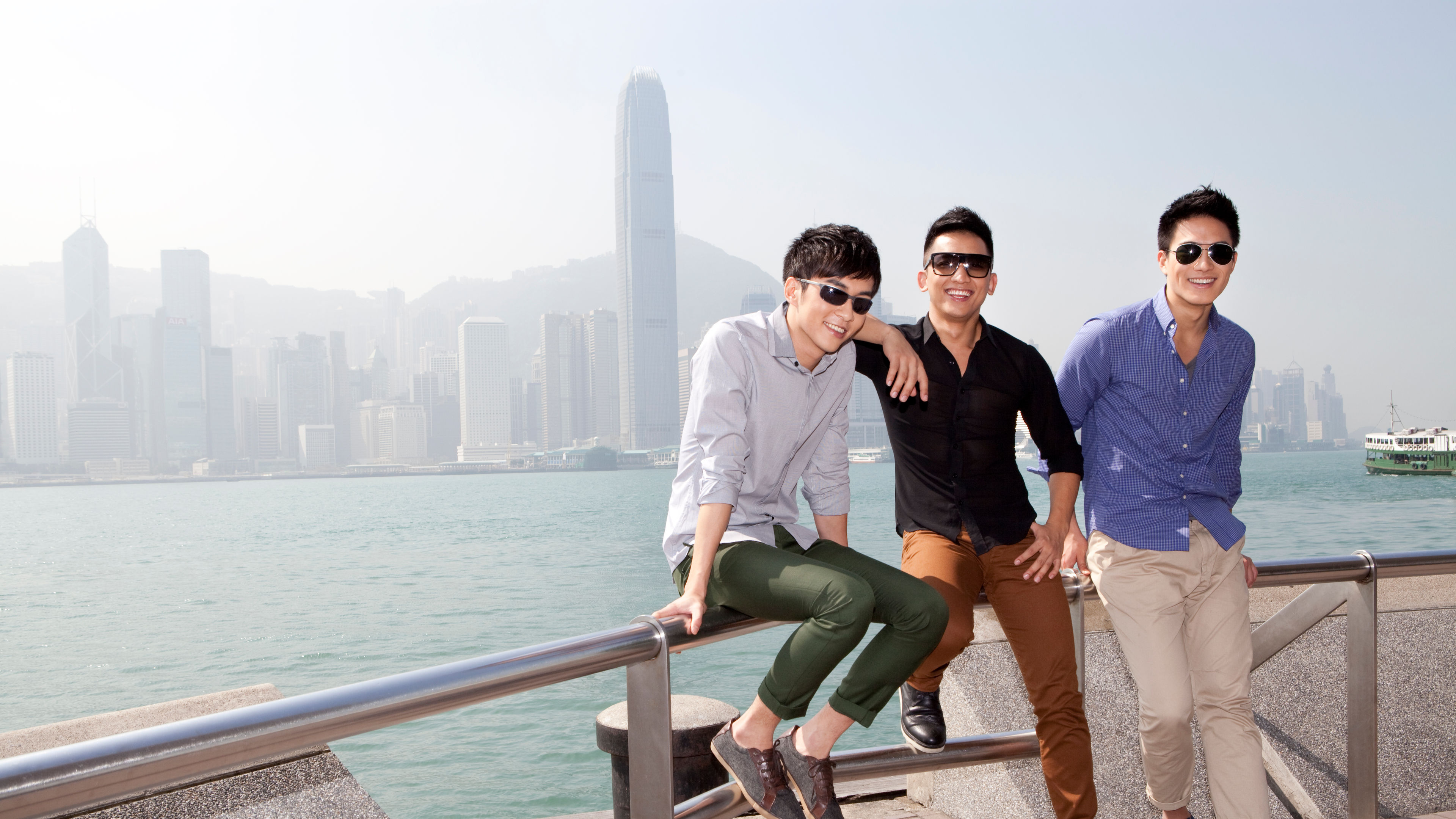 Fashionable young men enjoying the beautiful moment in Victoria Harbor 