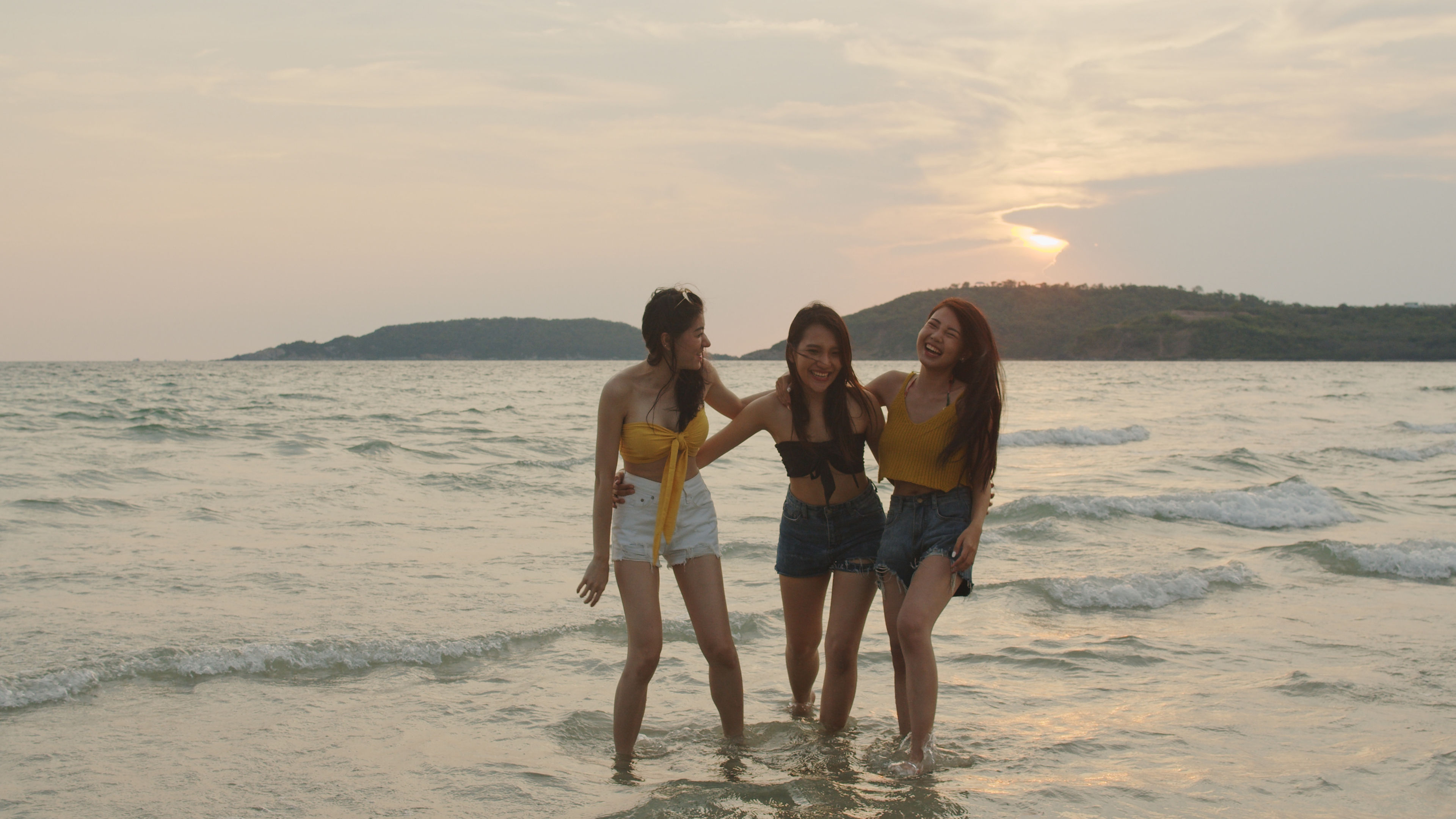 Friends relax on beach near sea when sunset in evening. 