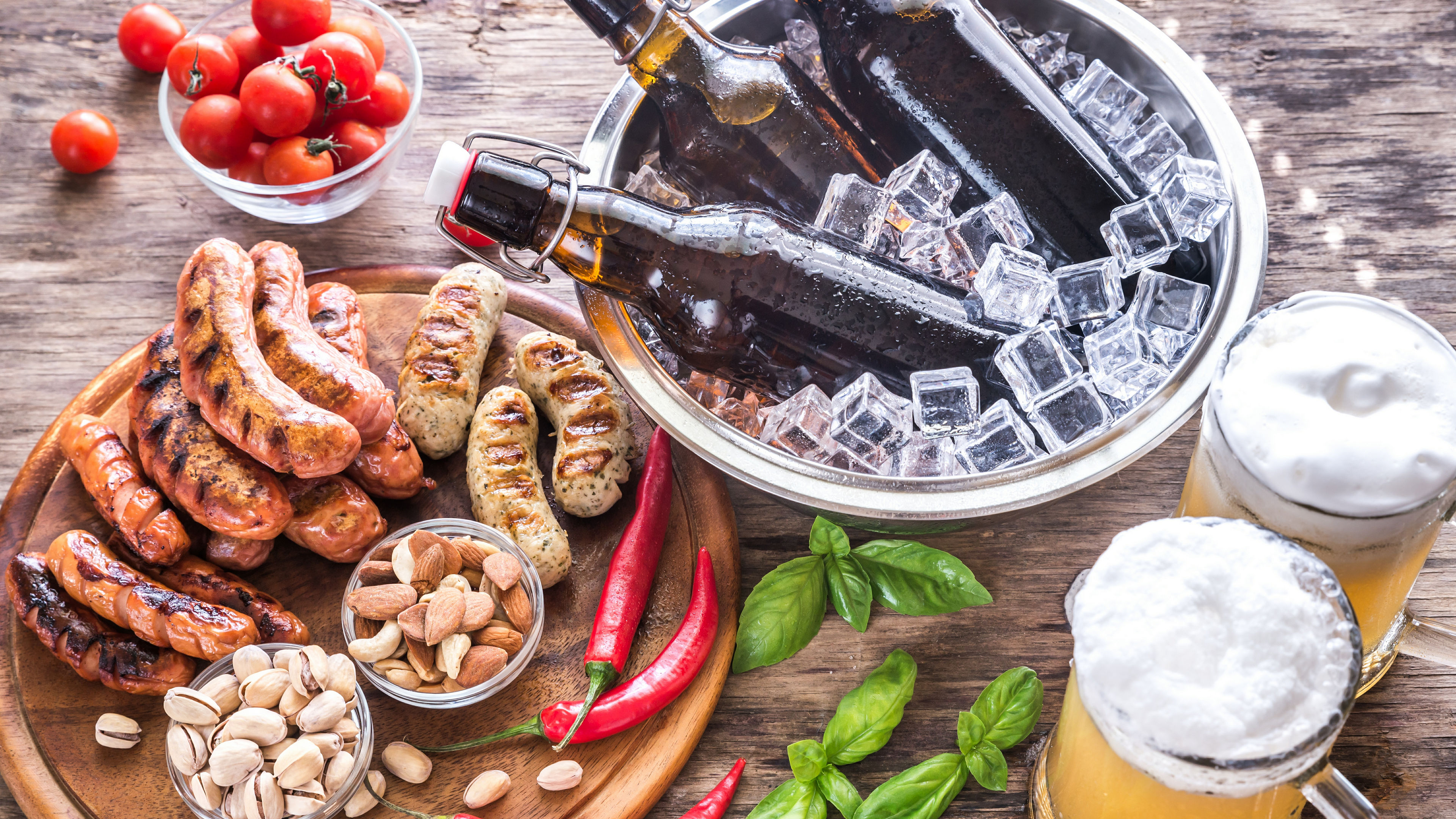 Grilled sausages with appetizers and mugs of beer