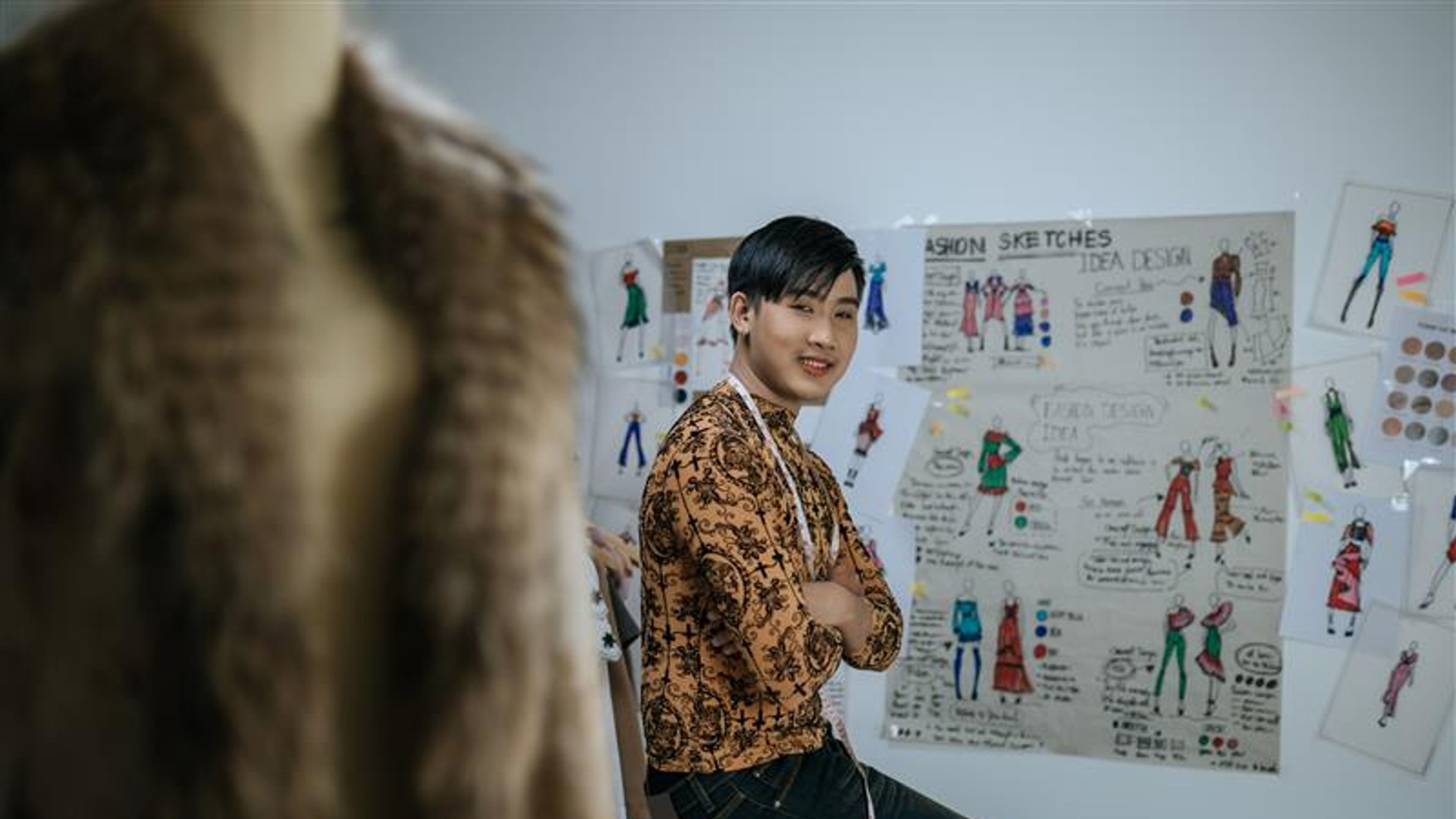 Portrait of Happy Asian young male tailor with measuring tape on neck
