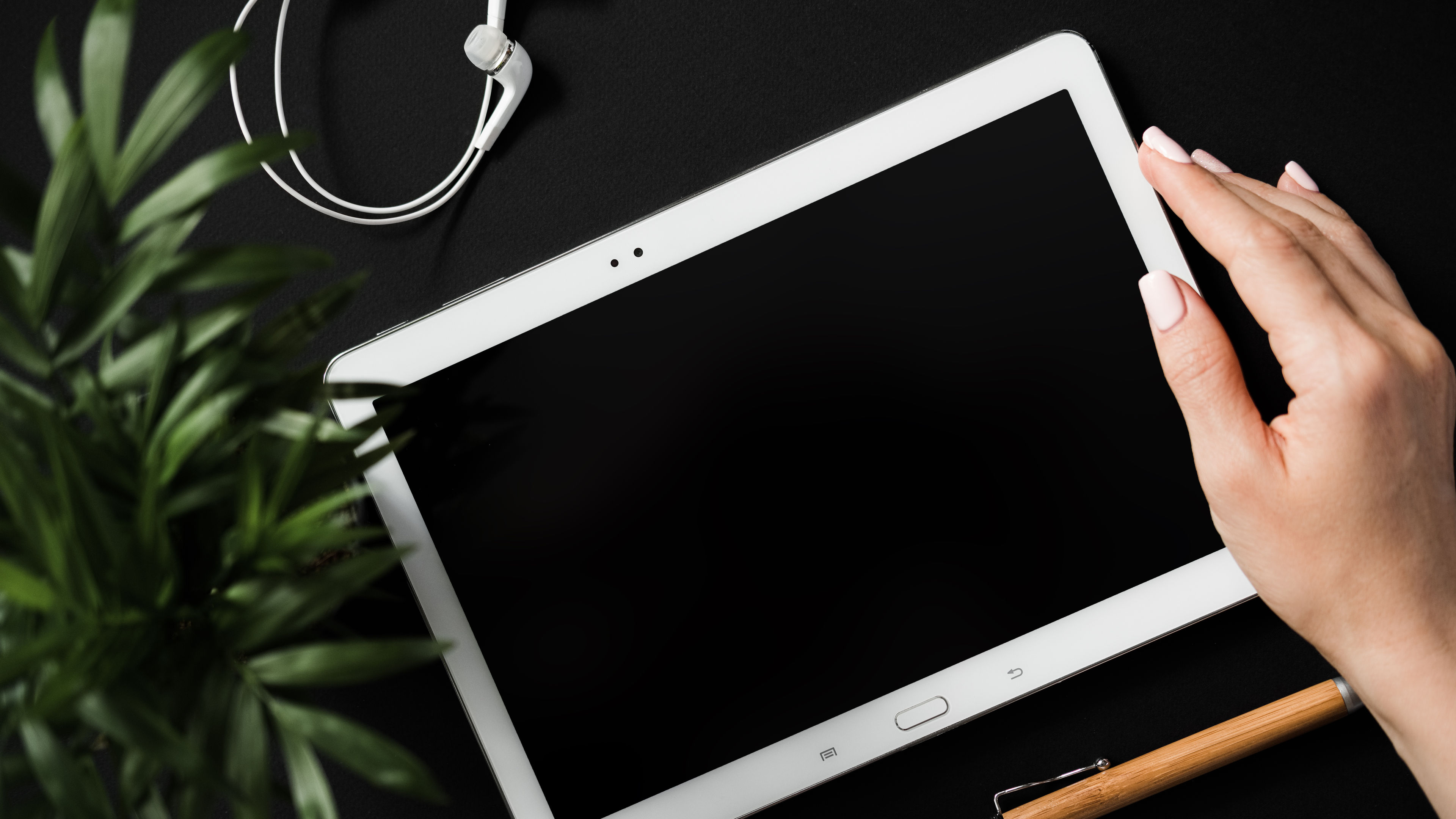 Top view of flat lay student's hand holds tablet