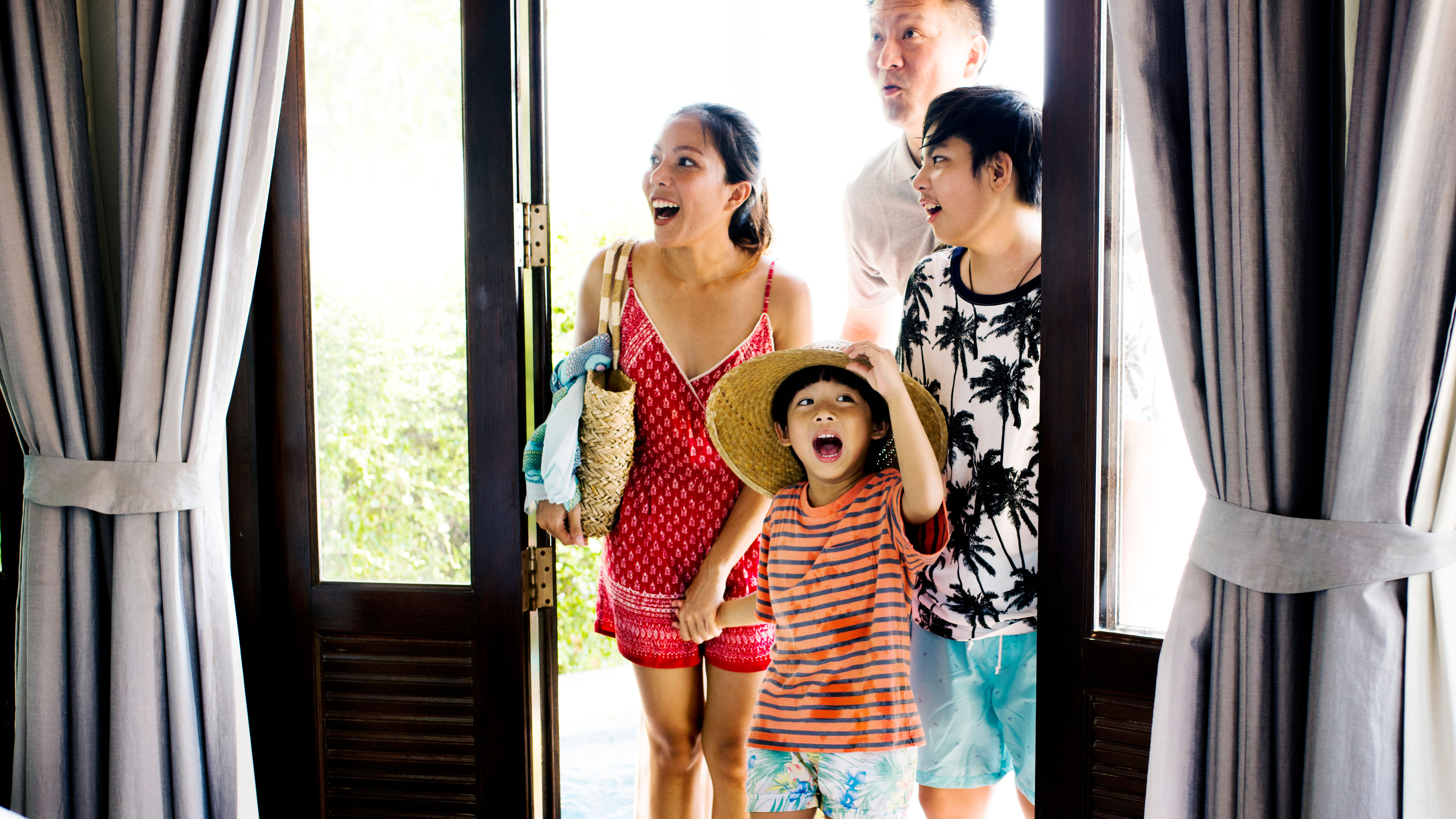 Asian family excitedly entering their hotel room