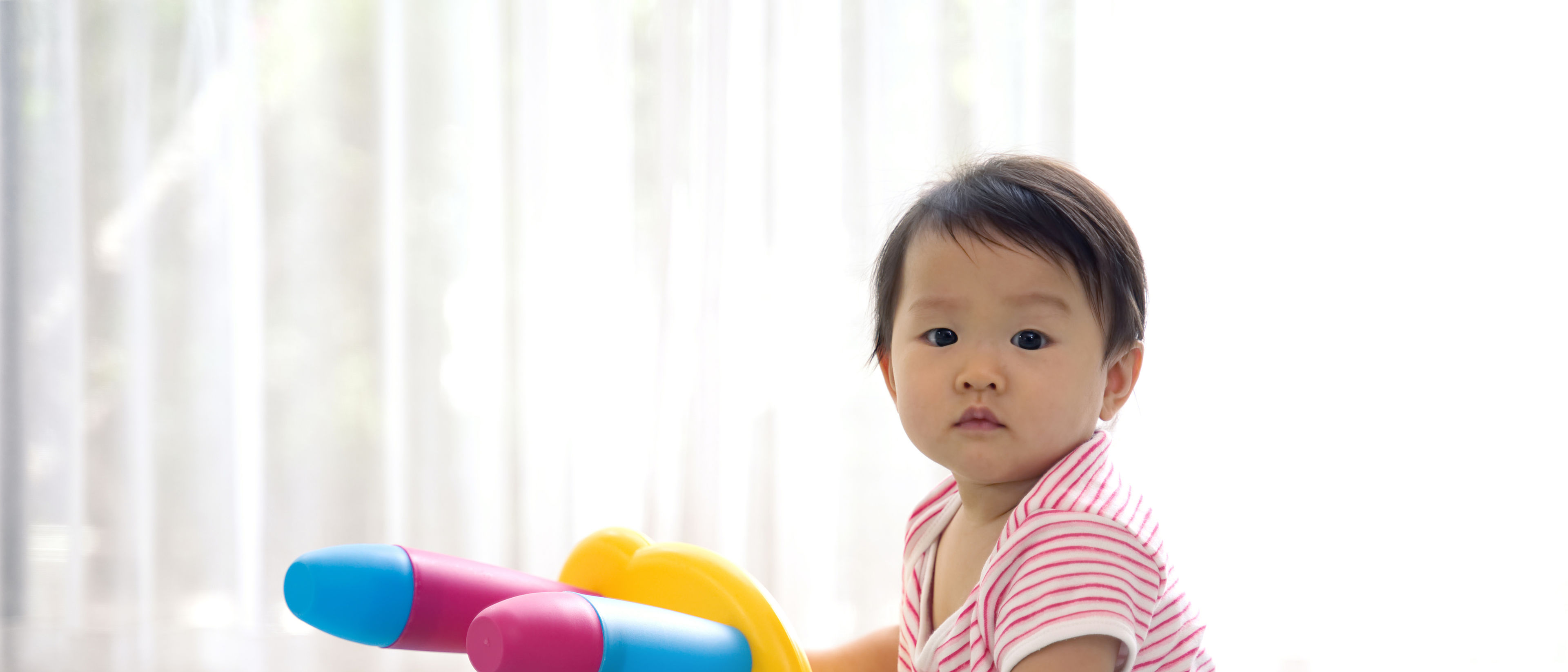 Cute boy playing with a colourful chair