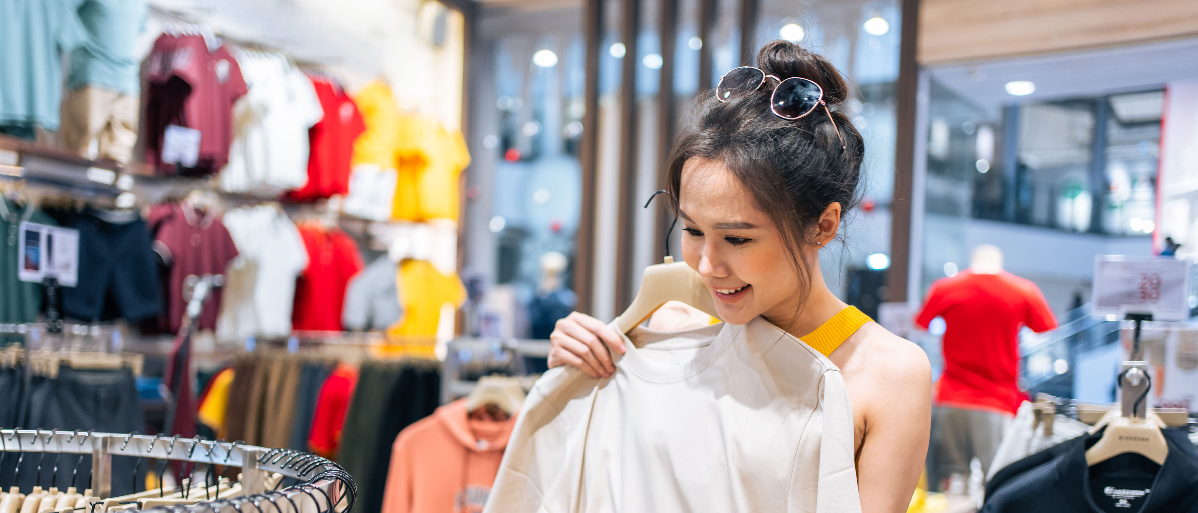 Young woman buying t-shirt from shop