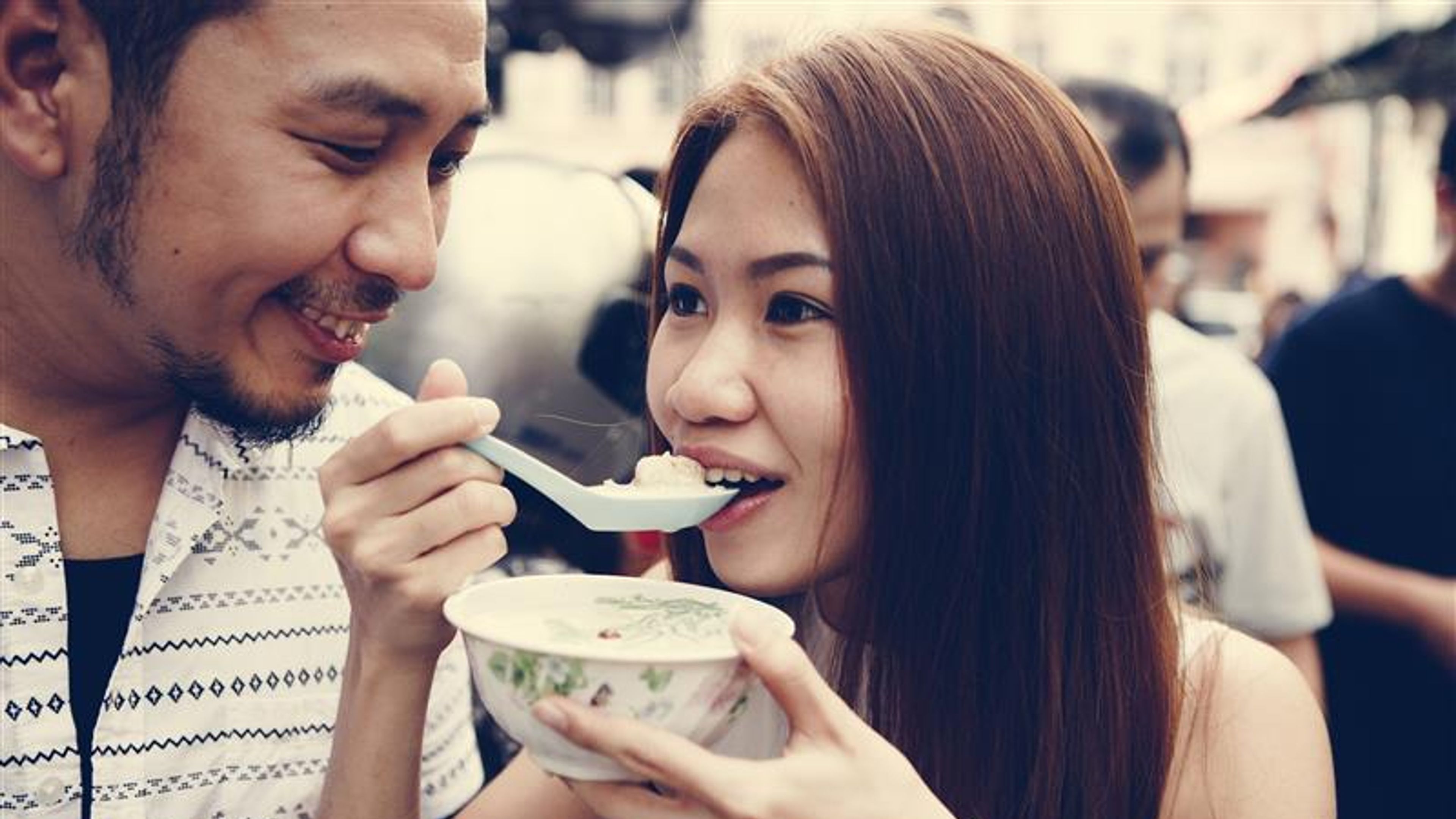 A couple having dessert outdoors.