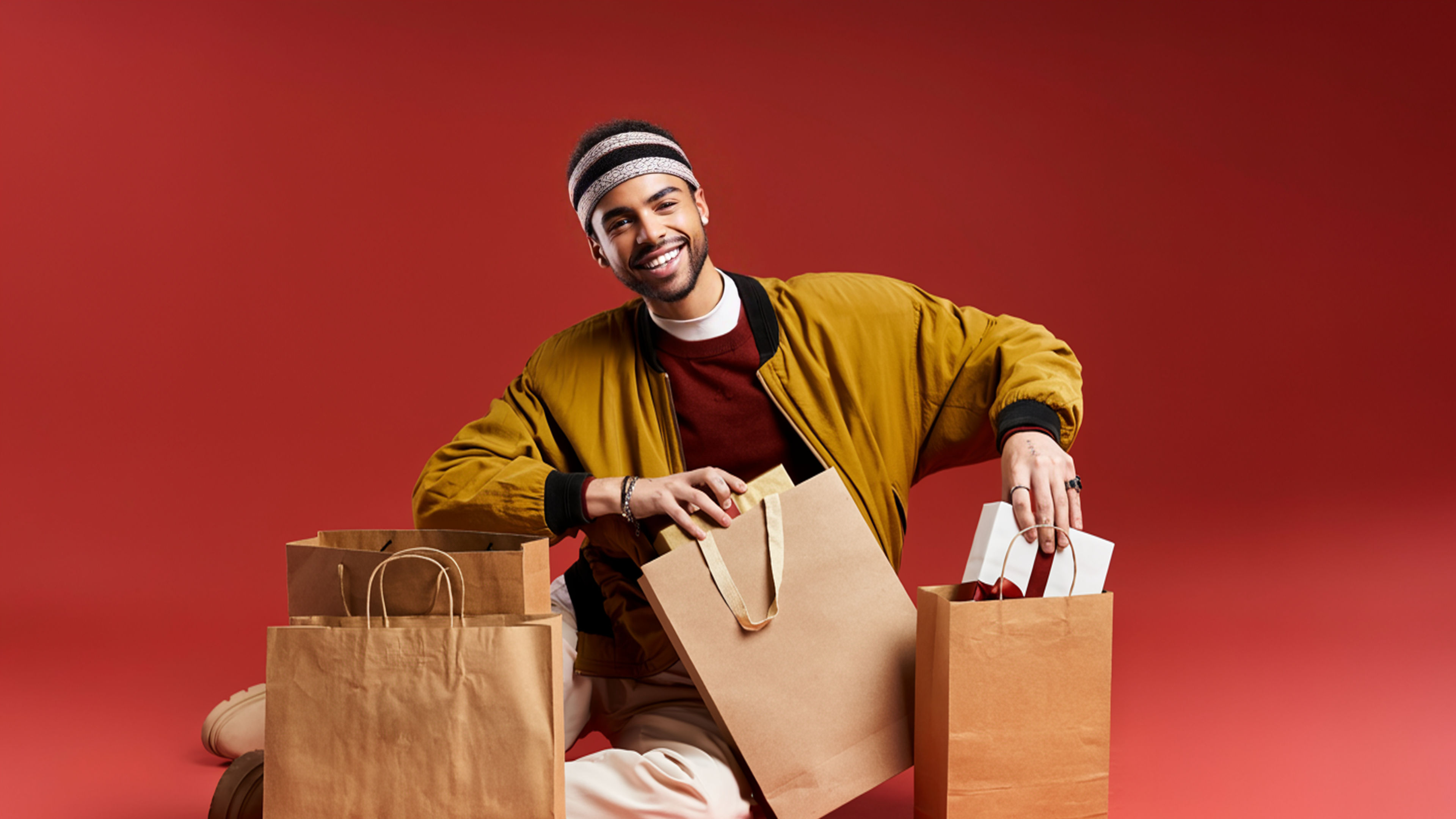 شاب أنيق يستمتع بالتسوق في الجمعة السوداء مع حقائب في استوديو