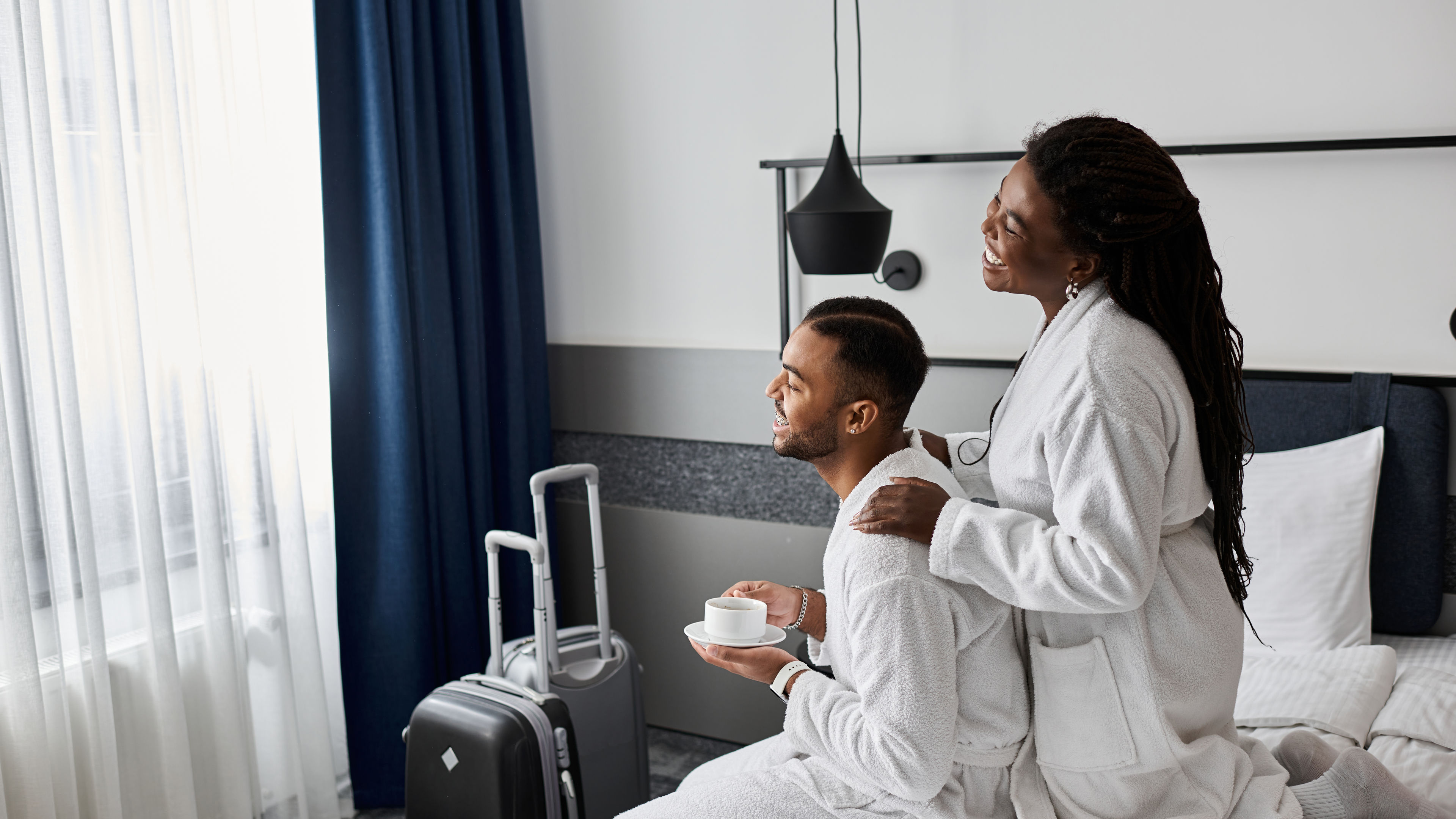 A joyful couple enjoying cozy moments in a hotel room on vacation.