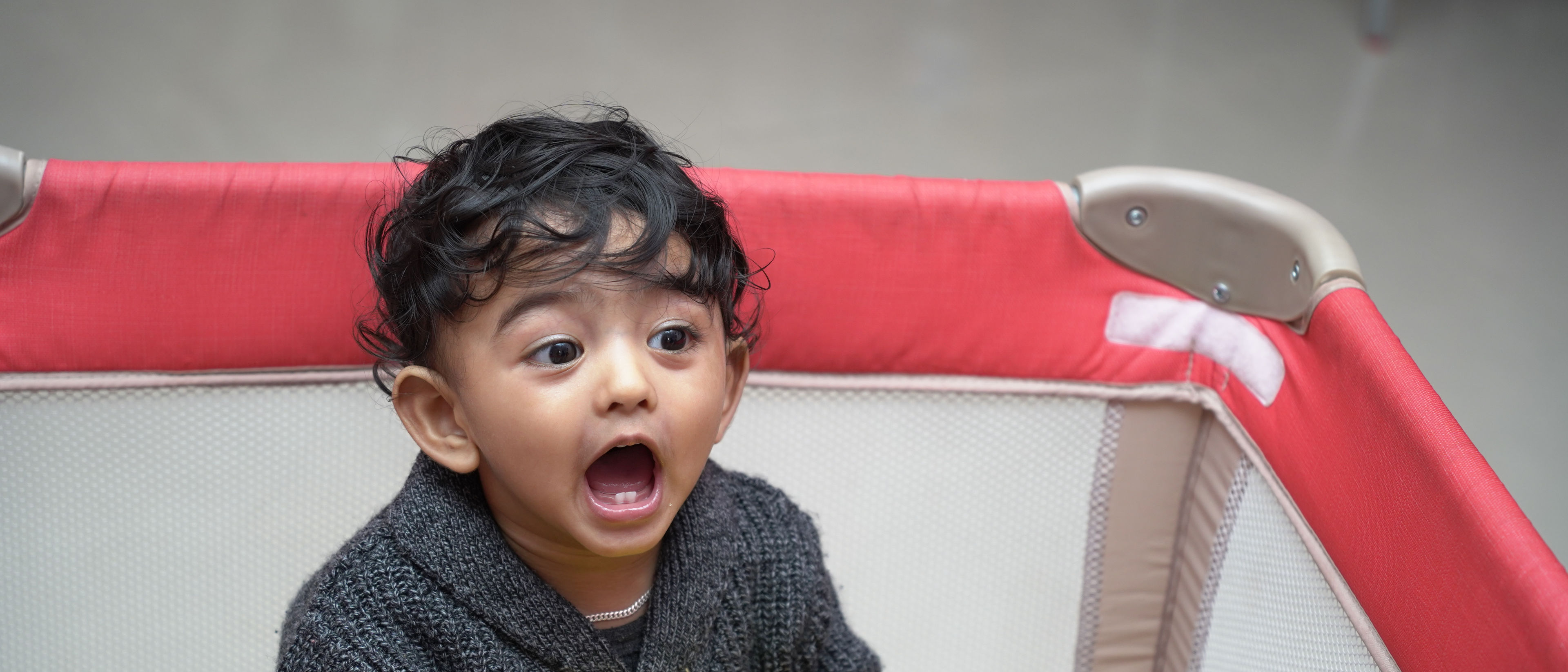 Adorable baby in a play pen