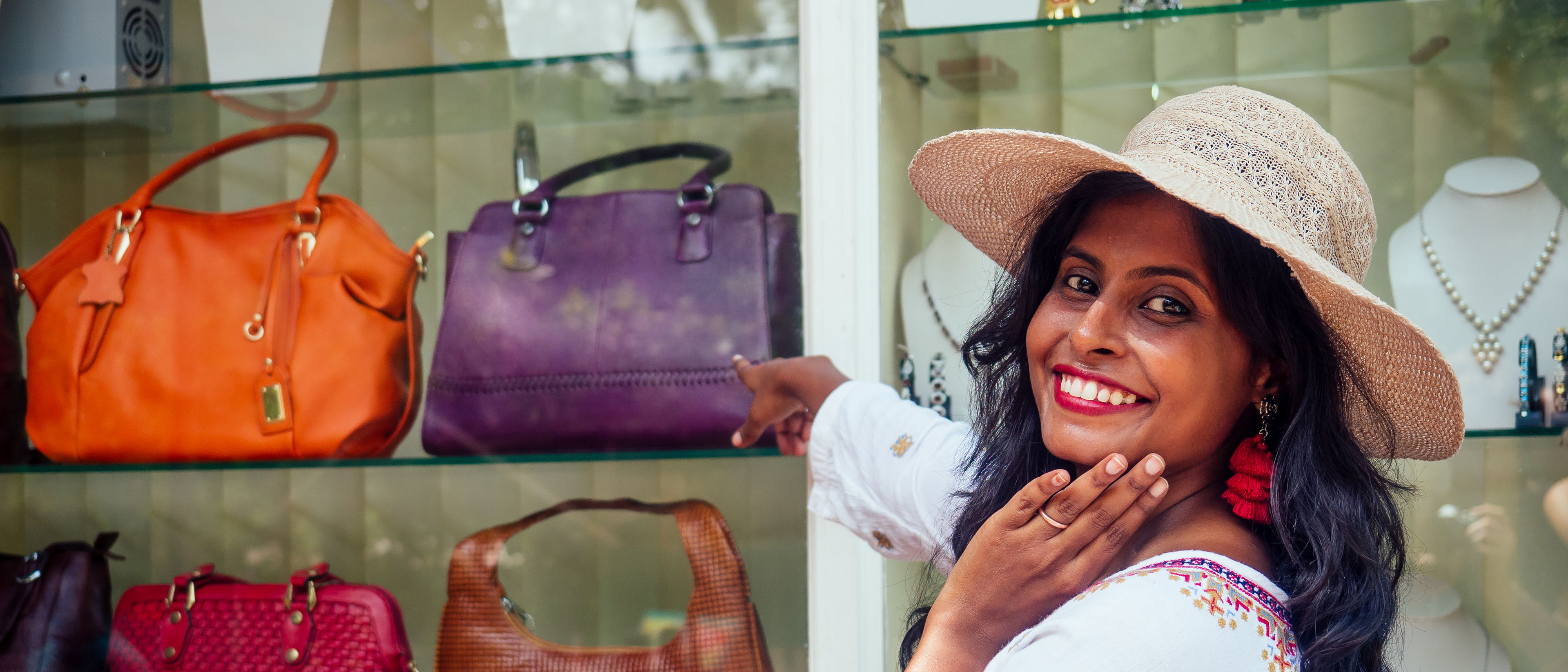 Happy woman in front of a bag store