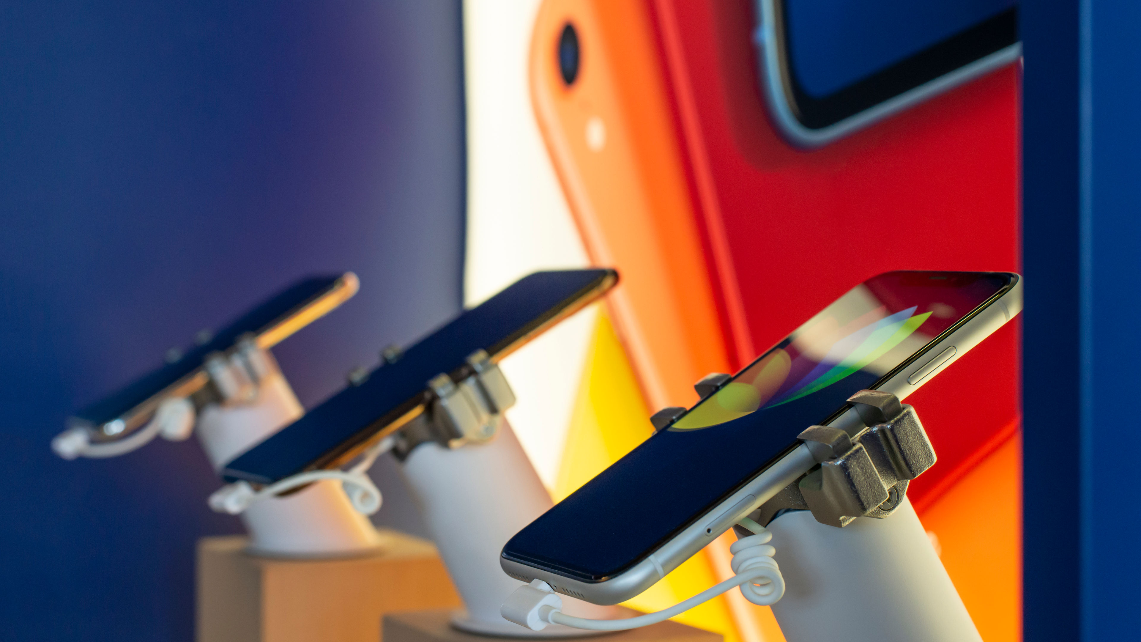 Three smartphones neatly arranged for display in a mobile shop.