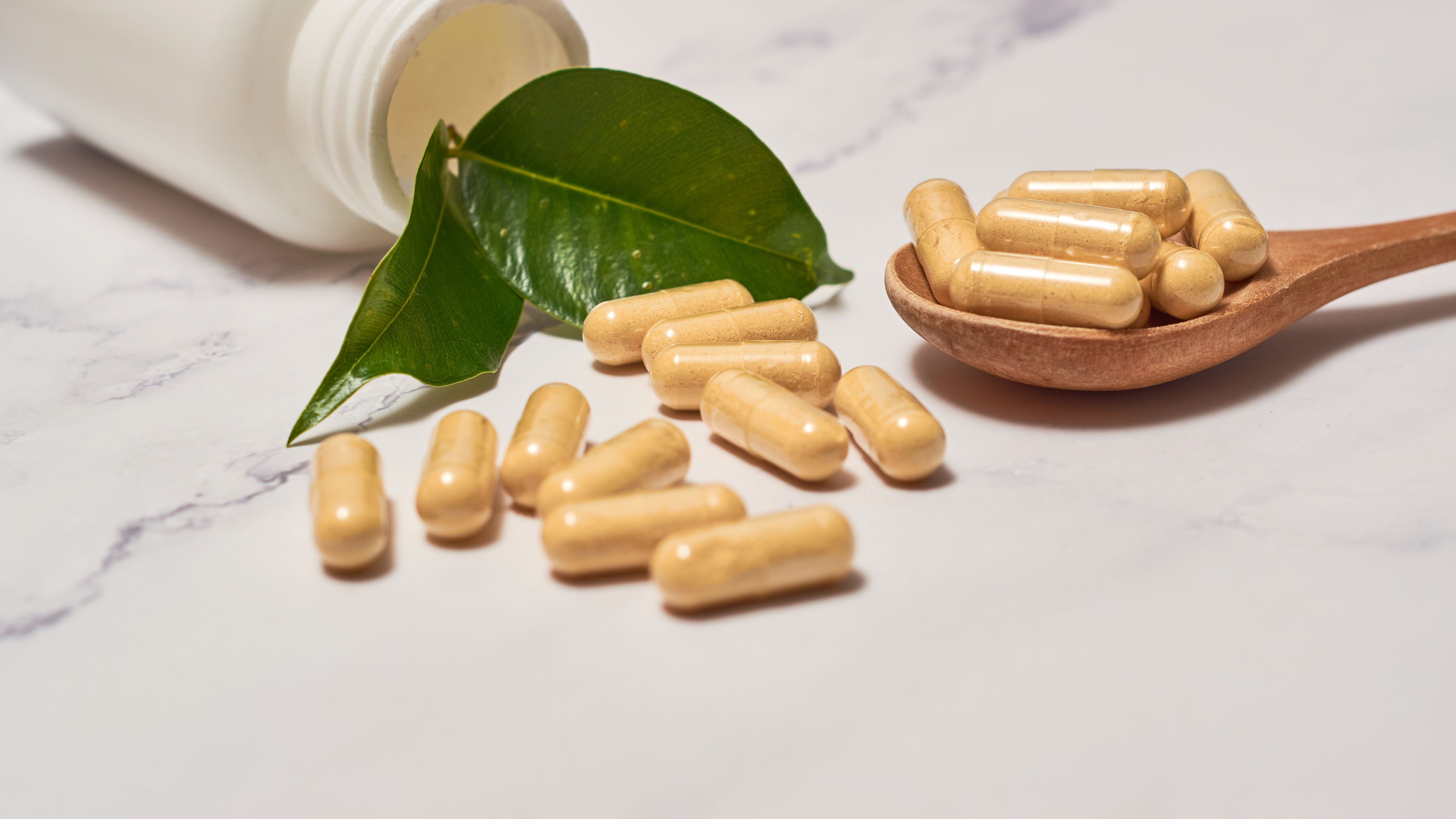 A captivating scene of capsules scattered on the floor, spilling out from an open glass bottle.