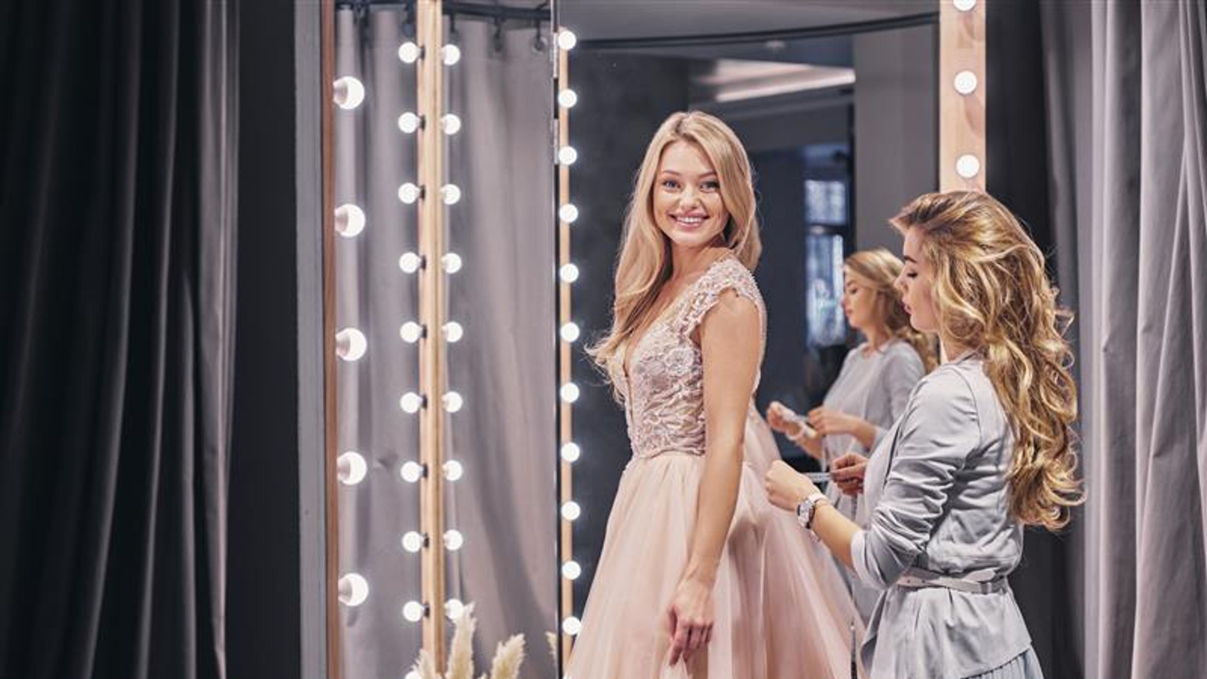 A woman looking at a mirror with new attire