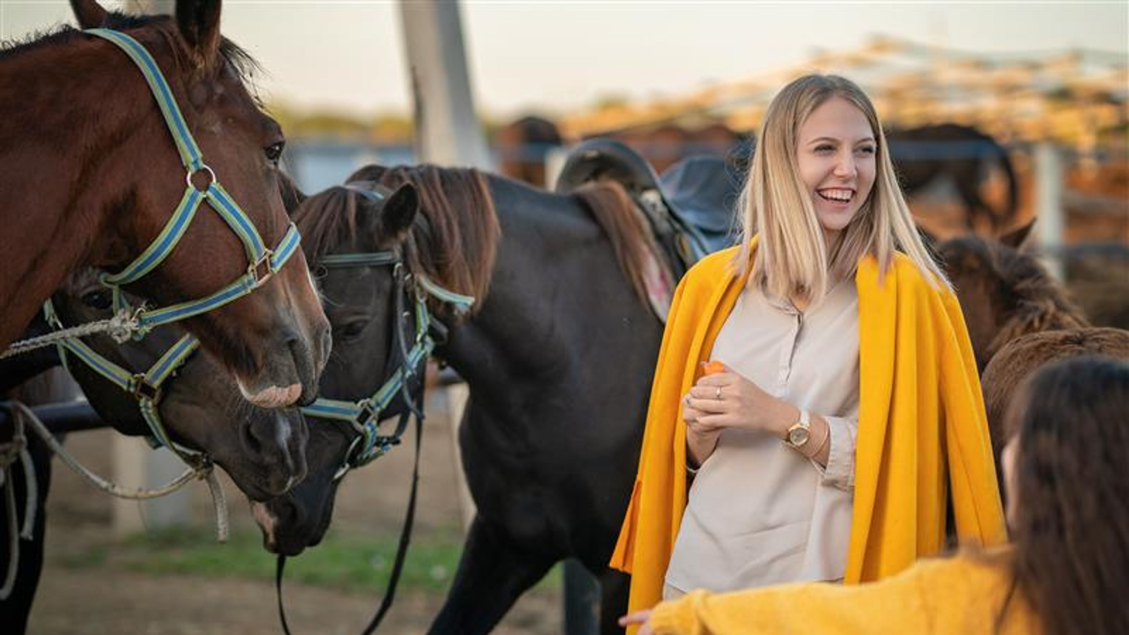 A woman with horses behind.