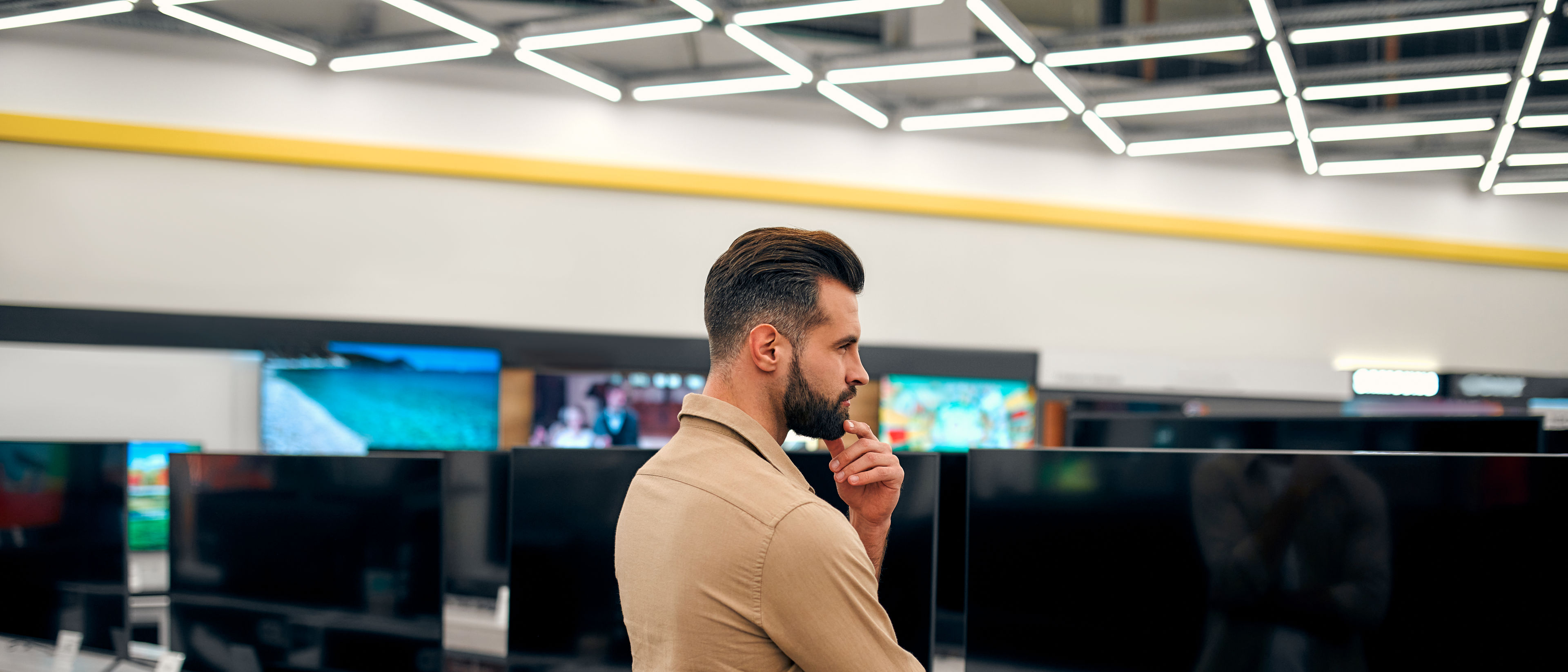 Confused man in TV shop