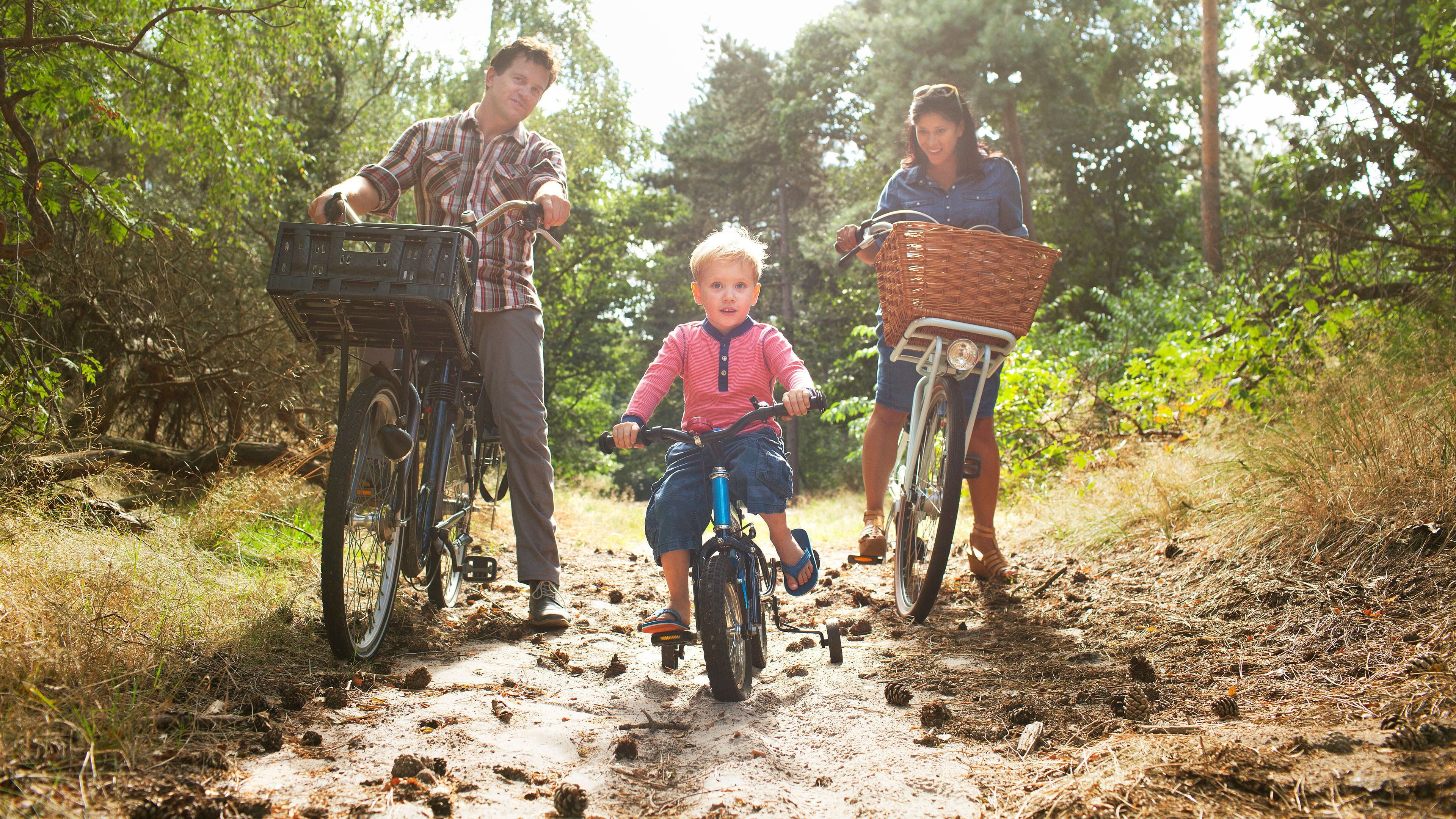 Family cycling through forest. 