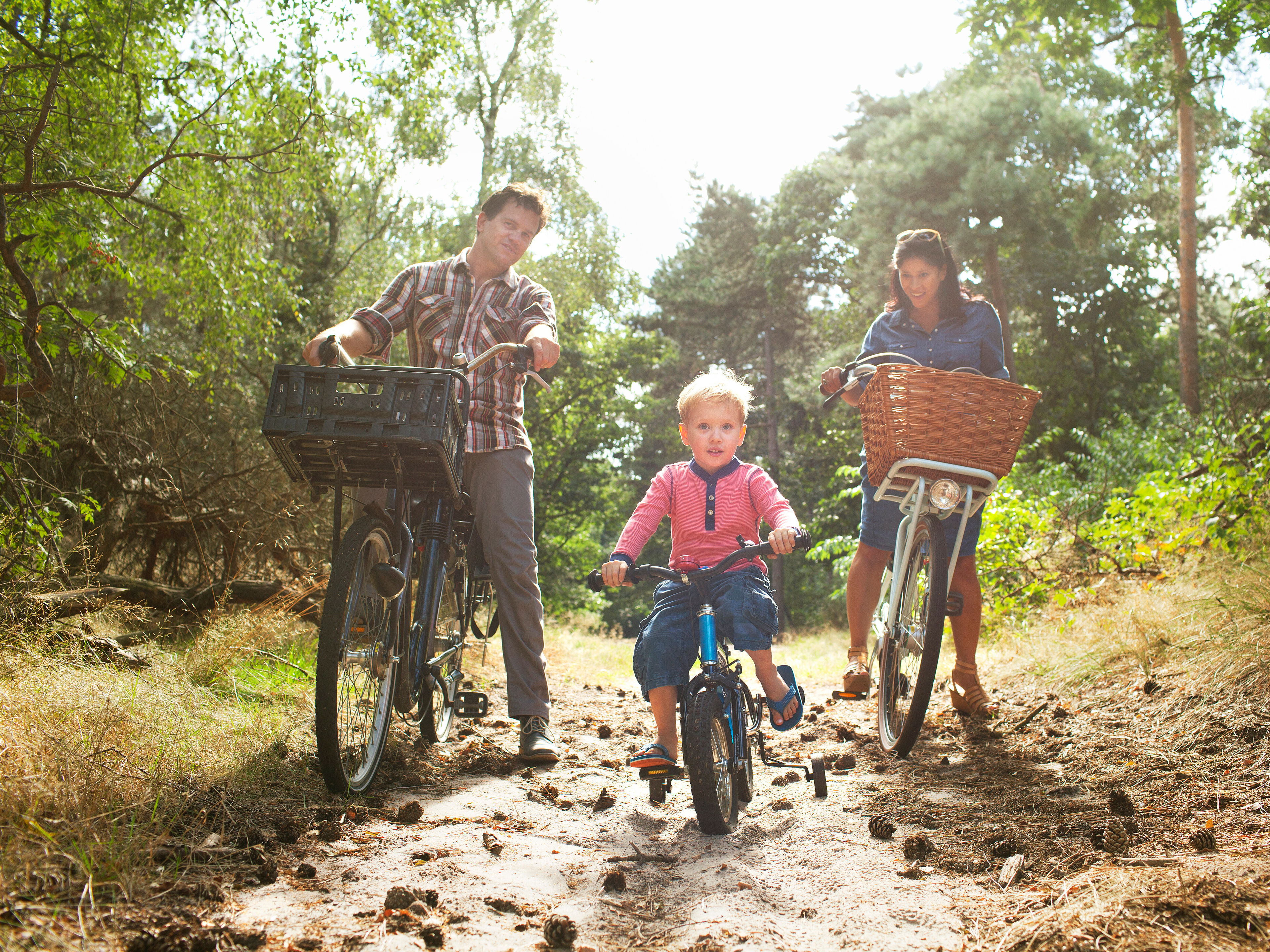 Family cycling through forest. 
